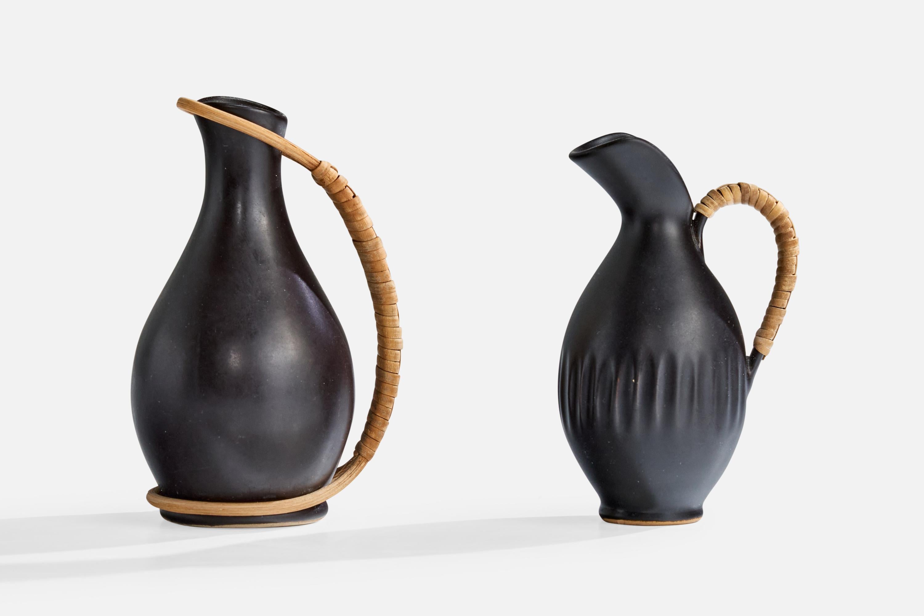 A set of two black-glazed ceramic and rattan miniature pitchers produced by Bofa Keramik, Denmark, c. 1960s.

Dimensions of Larger Pitcher (inches): 4.25” Height x 2.25” Width x 2.75” Depth

Dimensions of Smaller Pitcher (inches): 3.75” Height x