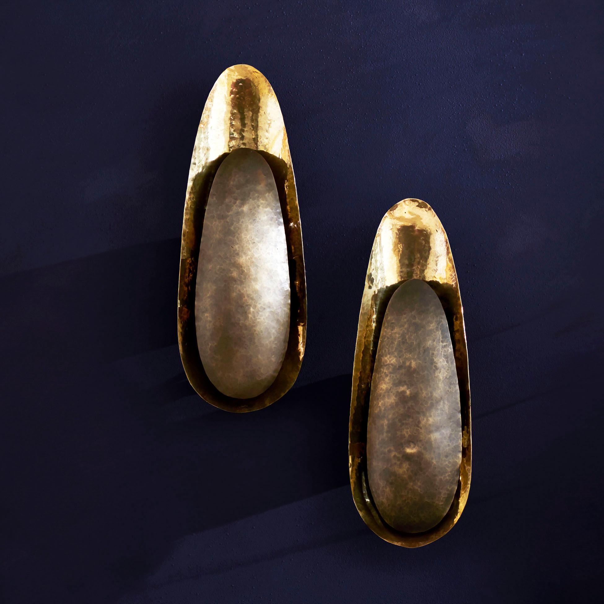 Le Bofty - une version plus petite de notre applique Lotus - est une fusion frappante de texture et de forme. Avec ses deux feuilles superposées en métal martelé à la main dans un contraste audacieux de patine et de bronze poli, cette pièce