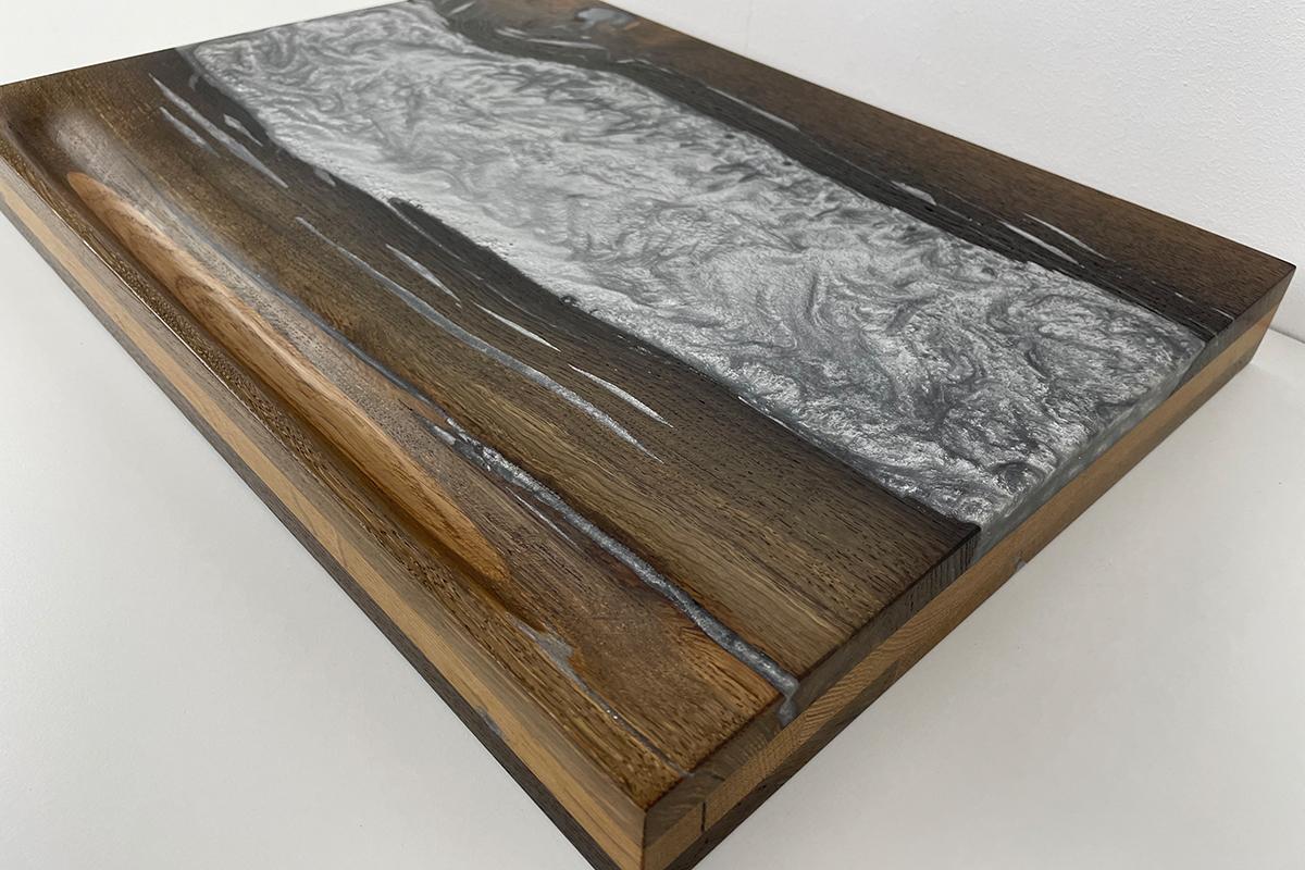 Cutting board made from 3000-year-old bog oak from the Vennermoor (near Münster). The bog oak was glued in several layers and cracks, knots, etc. were filled with high-quality epoxy. The surfaces are very finely ground and sealed with oil. In the
