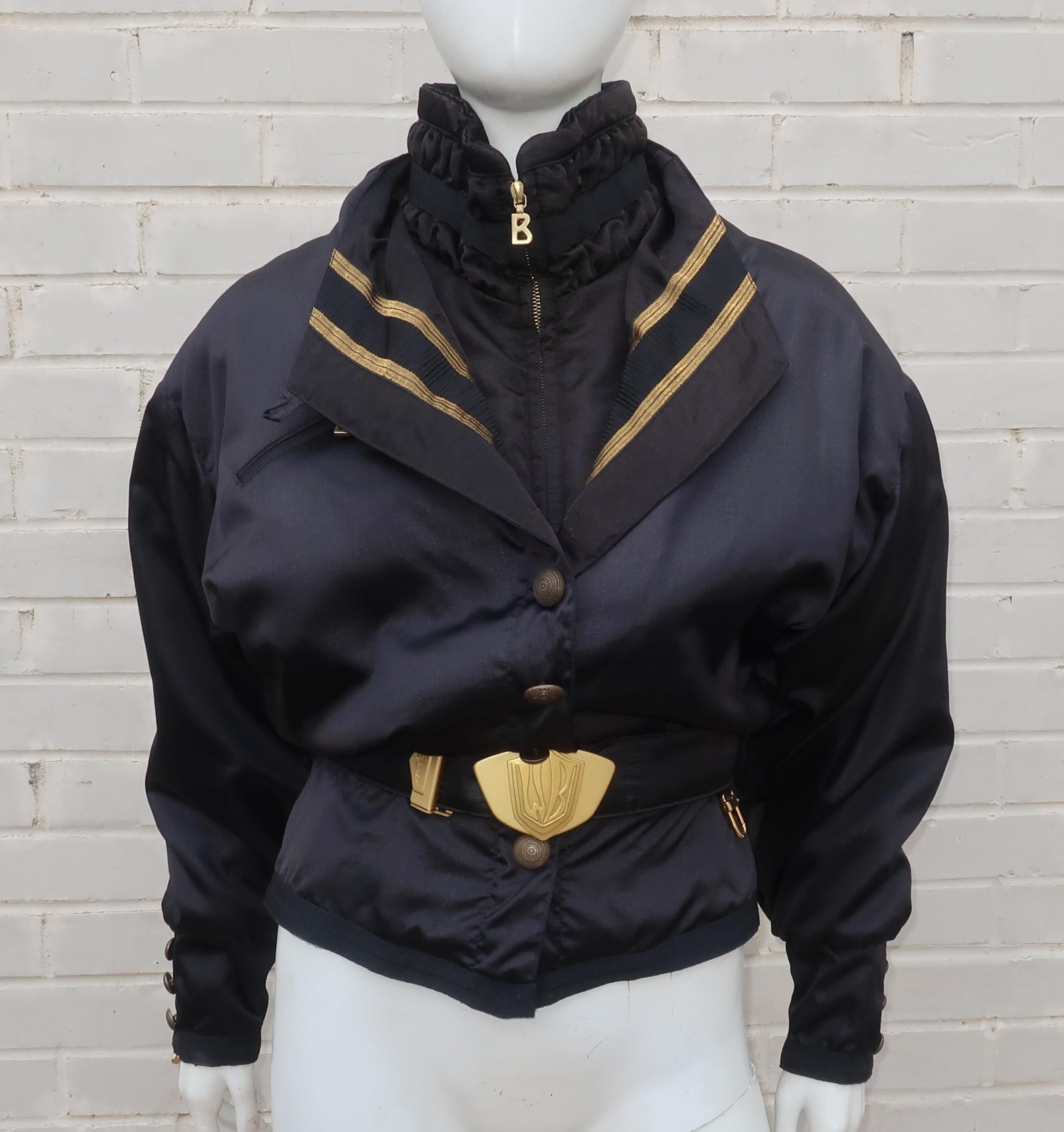 1980's glam style hits the slopes in a black ski jacket by iconic German sportswear designer, Bogner.  The classic ski jacket is made from nylon with cotton and polyester padding accented by gold lame trim, Norwegian folkloric brass buttons and the