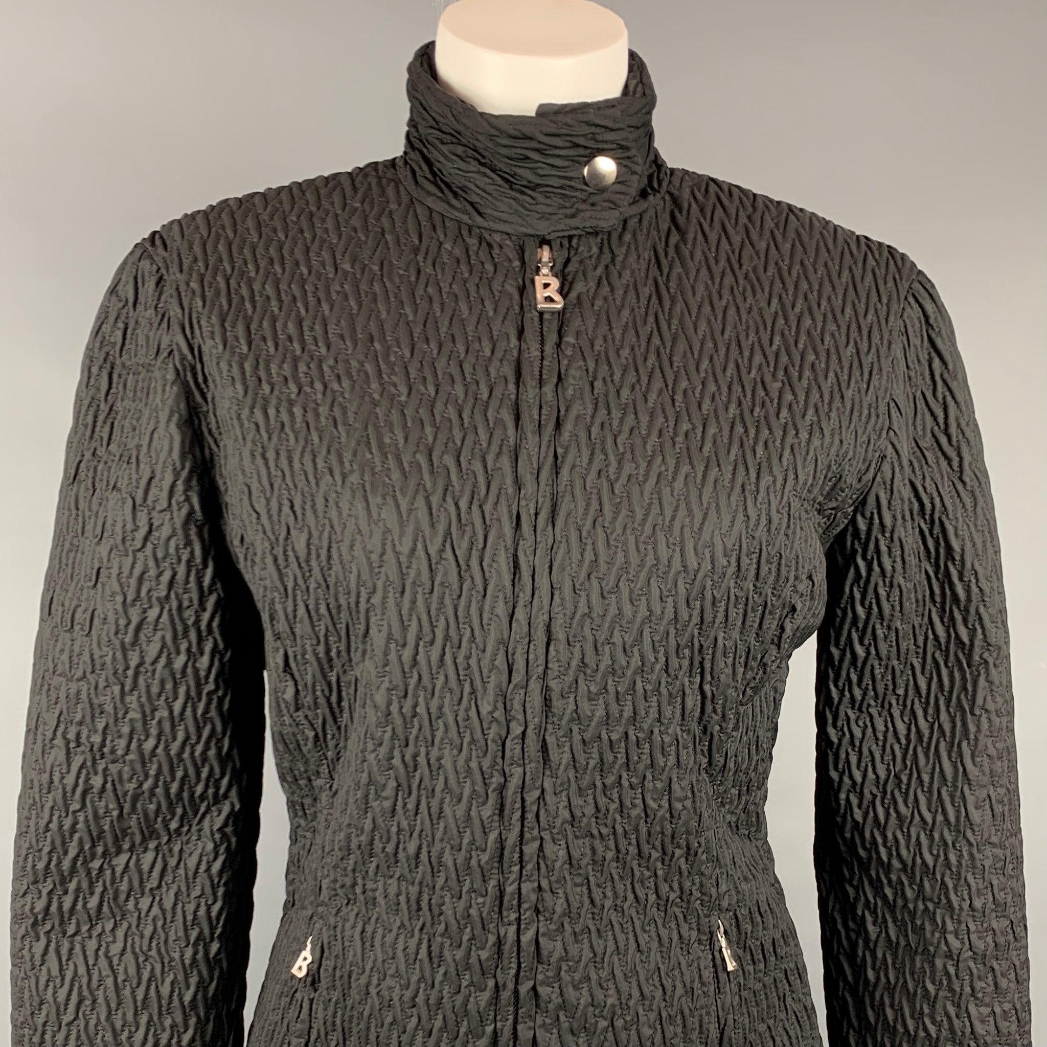 BOGNER jacket comes in a black textured quilted nylon featuring a buttoned collar, silver tone hardware, and a full zip closure. Made in USA.Very Good
Pre-Owned Condition. 

Marked:   6 

Measurements: 
 
Shoulder: 18 inches  Bust: 38 inches 