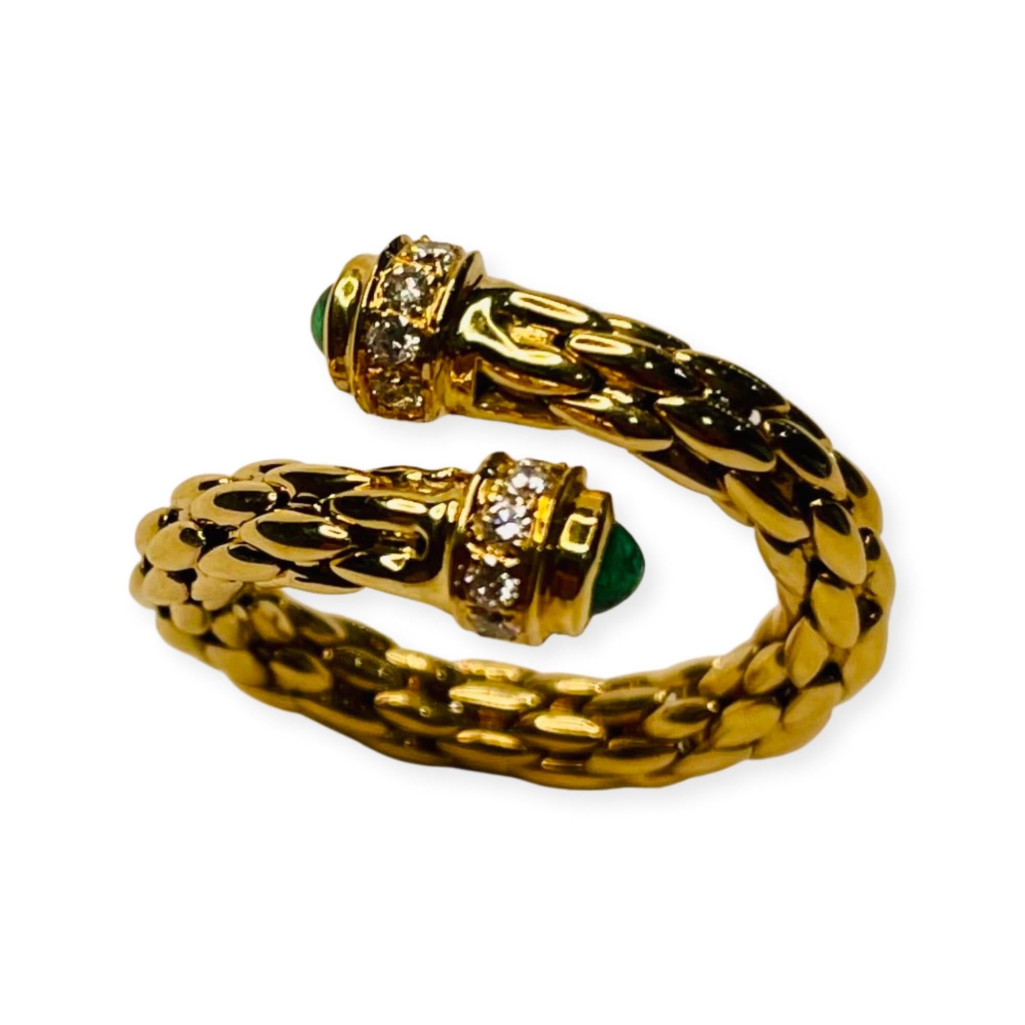Bogo 18K Yellow Gold Emerald and Diamond Ring. This ring is a fabricated 3.9 mm wide flex band made with interlocking links. It is a bypass design. There is a 2.5 mm natural emerald cabochon, bezel set, in ends of the ring. There are 5 full cut