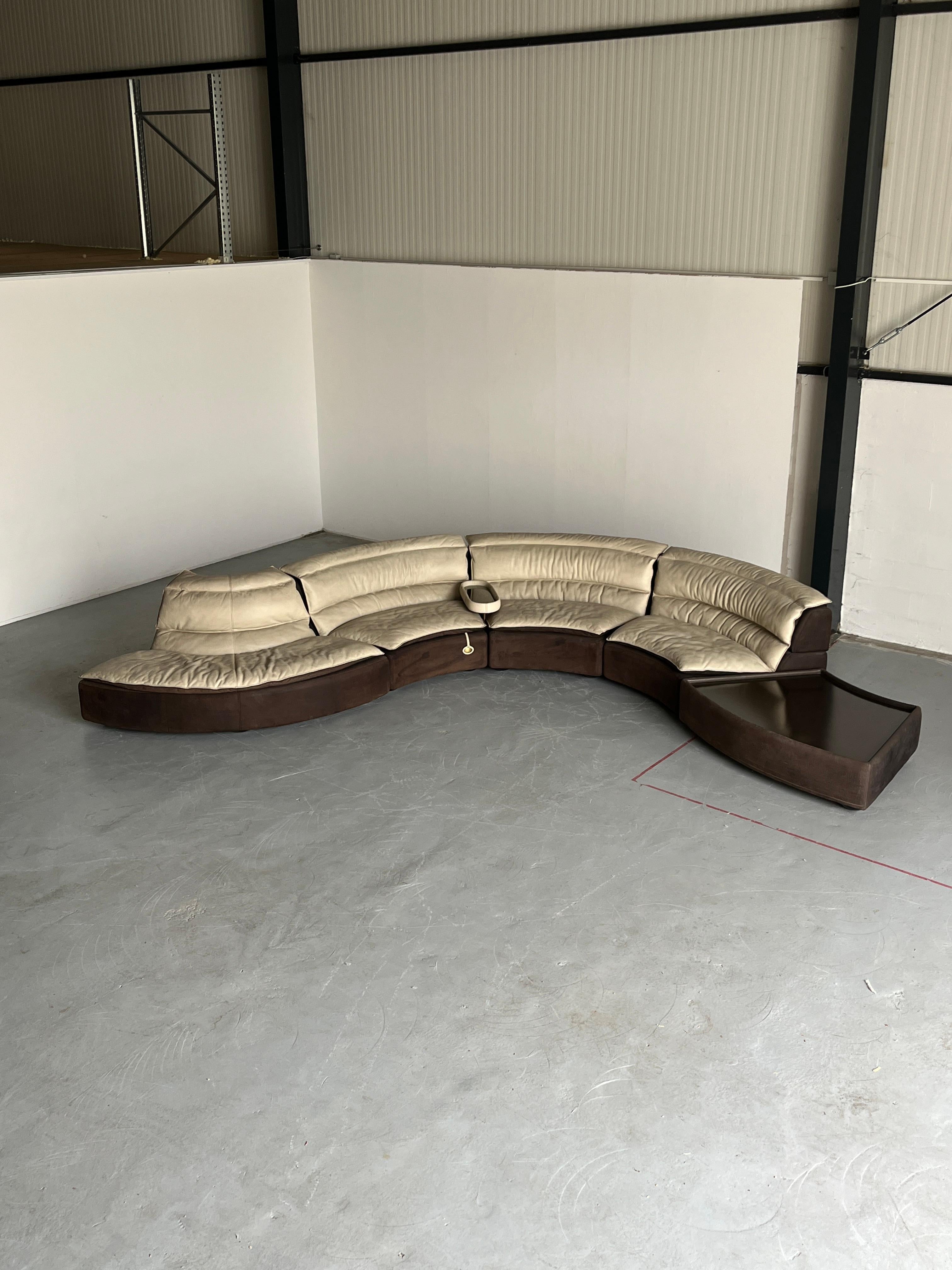 A stunning vintage serpentine modular sofa designed by Carlo Bartoli as a part of the 'Bogo' luxurious furniture series produced by Rossi di Albizzate.
The seating system consists of four seating elements and a table, which gives the opportunity to