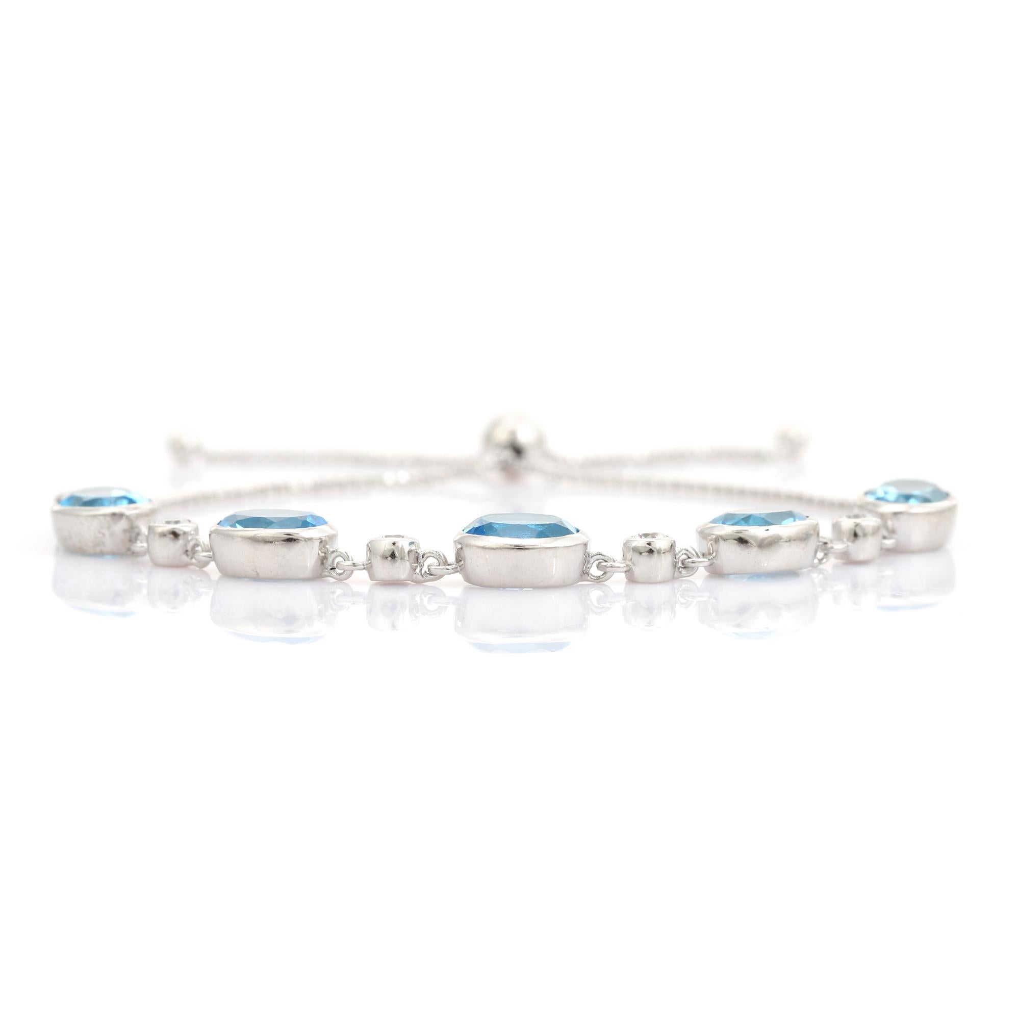 This Bohe Oval Blue Topaz Adjustable Aliding Clasp Link Bracelet with White CZ Stone exquisite 925 sterling silver bolo bracelet, artfully set with five vivid oval-cut blue topaz gemstones. Each brilliant blue stone is interspersed with bezel-set
