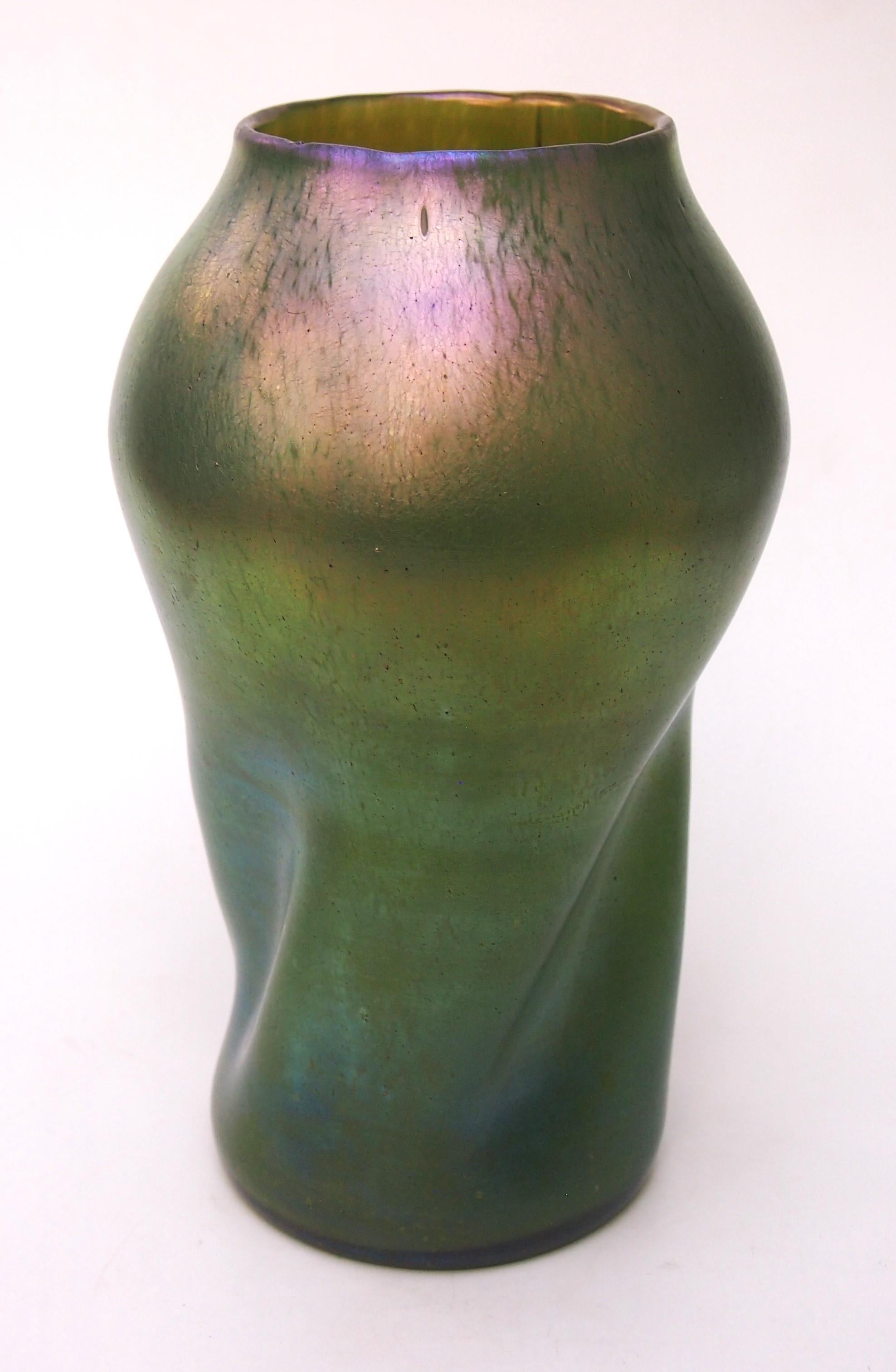 A large Loetz Delphi pattern vase in green with a bulbus near spherical top with a large opening over a round base with a typical Loetz twist to the body. Finely iridised a classic Loetz vase in a classic Loetz pattern

The Loetz Delphi first
