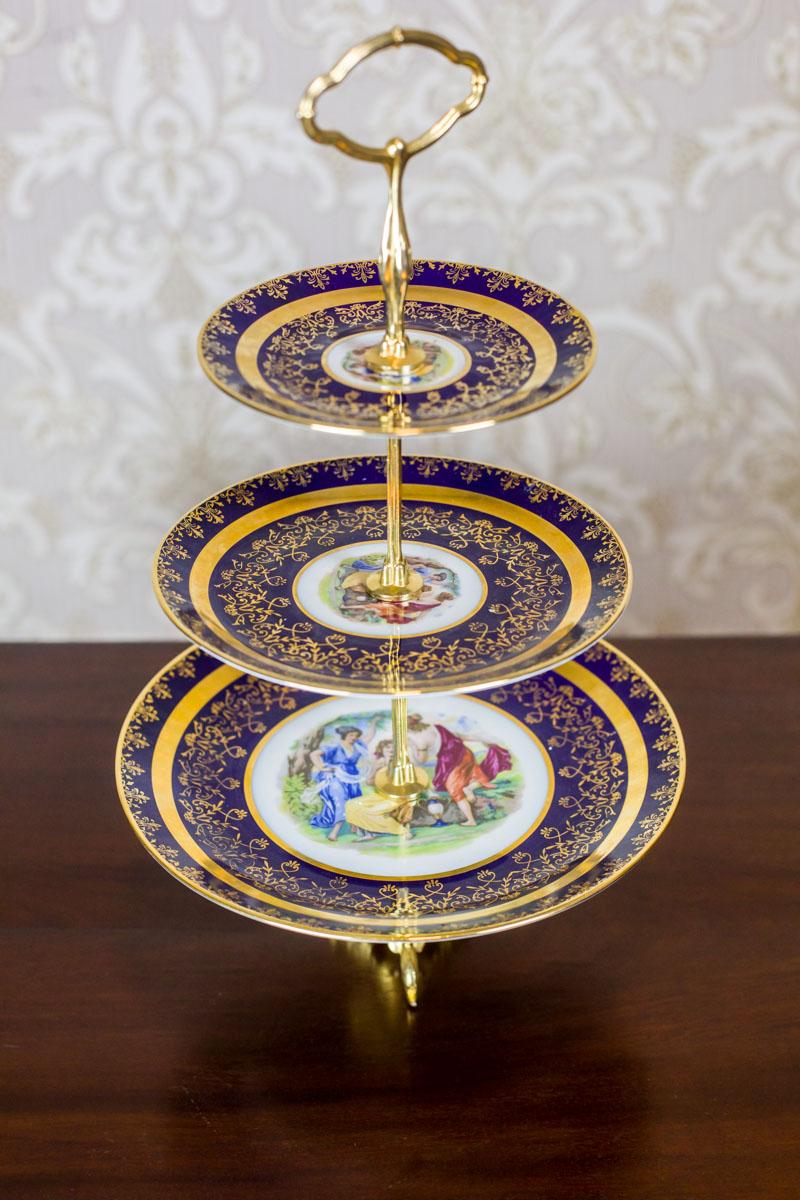 We present you this epergne composed of three tiers of cobalt plates with mythological scenes in the center and a 24-karat gold ornamentation.
The epergne comes from the famous, historical glass and porcelain manufactory, Bohemia.
Furthermore, the