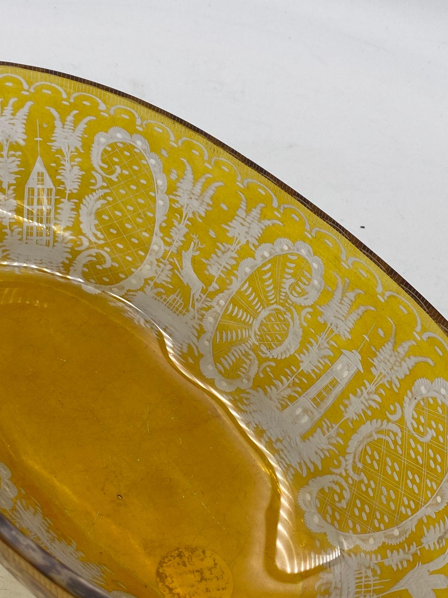 Eine böhmische Schale aus bernsteinfarbenem Überfangglas in ausgestellter Form mit geätztem gelbem Überfangdekor, der Auerhähne oder ähnliche Wildvögel in einer Seeszene darstellt.