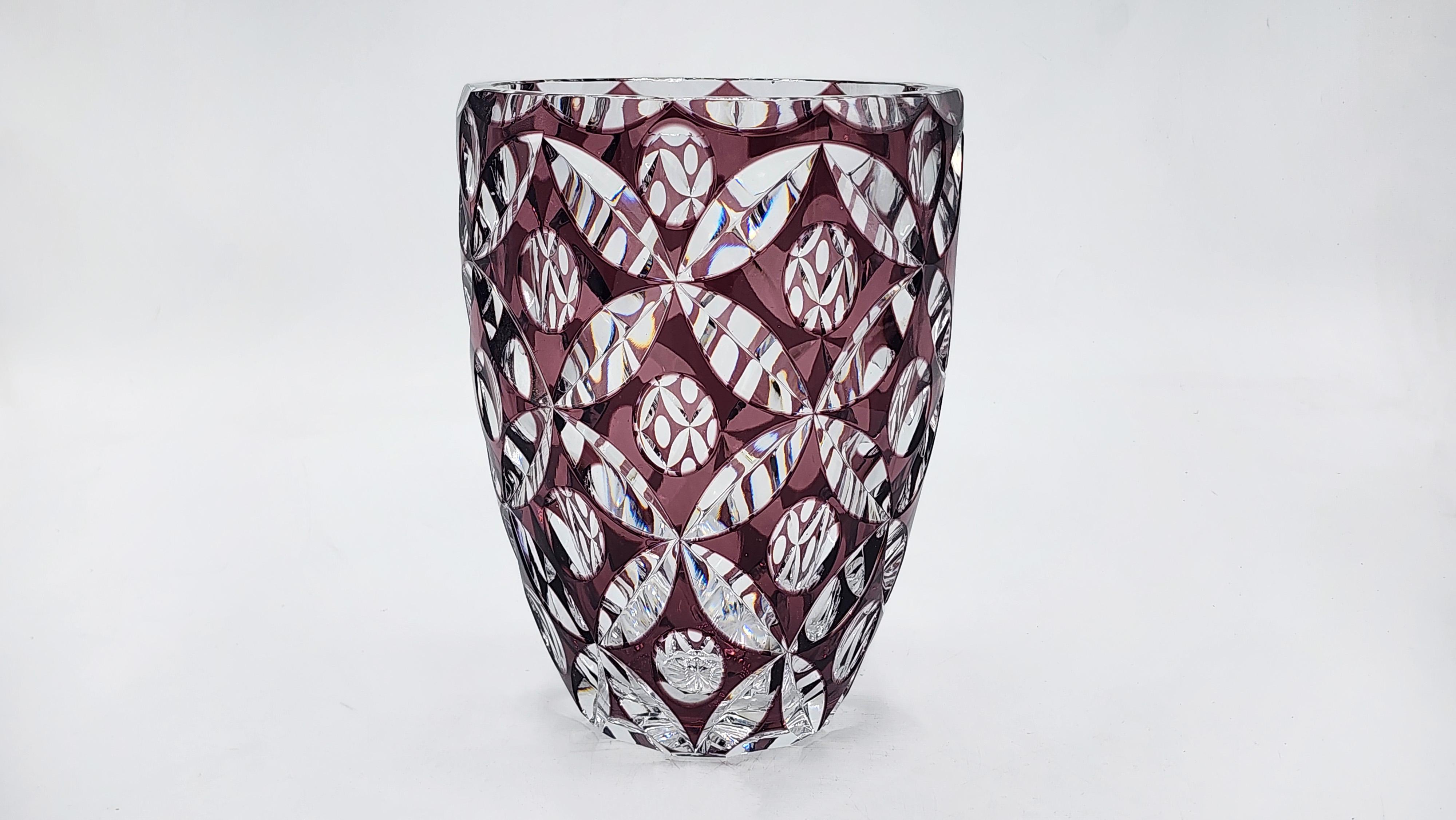 Jarrón bohemio de cristal tallado Art Déco
Este jarrón bohemio de vidrio tallado Art Déco tiene forma cilíndrica con un diseño geométrico y floral. Su color morado oscuro o amatista se ve realzado por cortes profundos y transparentes que crean