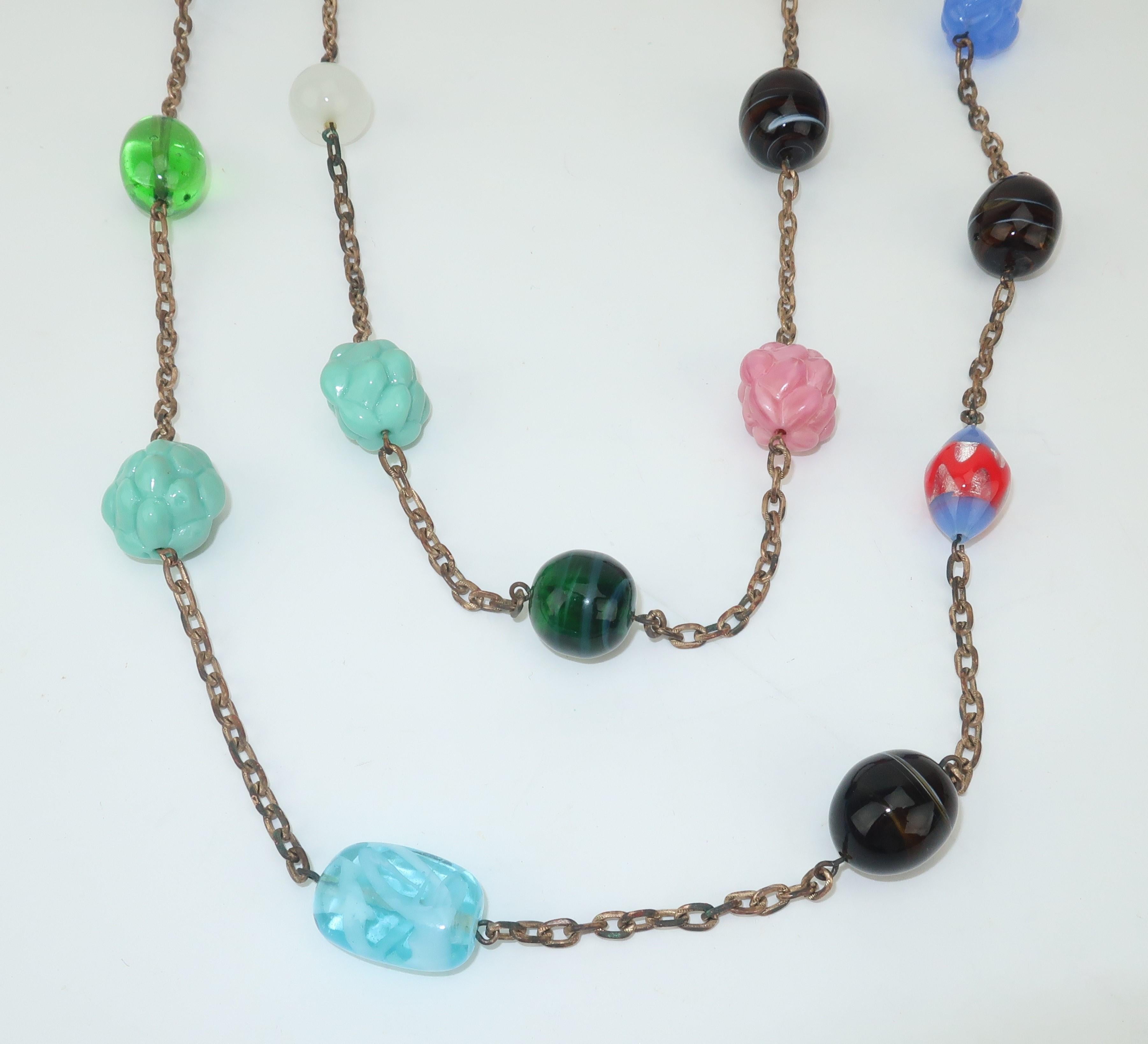 Add a touch of boho chic to your wardrobe with this C.1960 opera length chain necklace accented with art glass beads of different shapes and colors.  Measuring an amazing 61