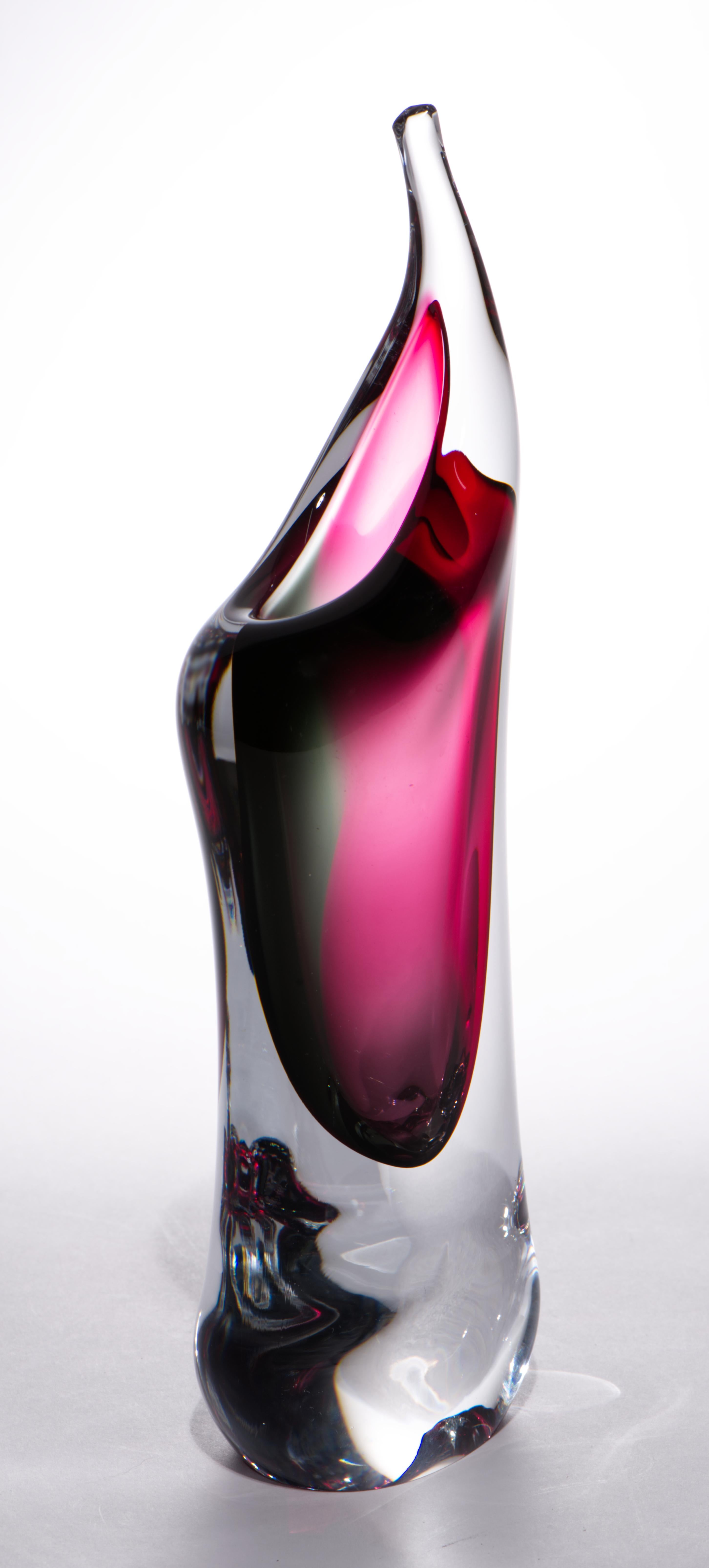 Ce vase à bourgeons en verre d'art bohémien de style vintage présente un cœur en verre rouge et sarcelle foncé, semblable à un bijou, entouré d'une couche de verre clair selon la technique sommerso. La forme asymétrique et fluide du vase ajoute une