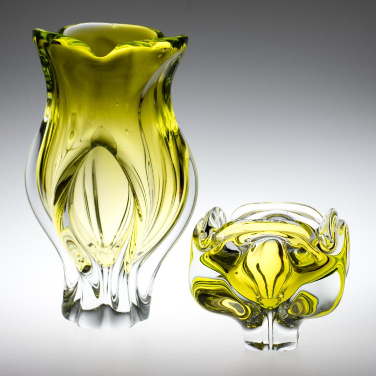 Theese wonderful high massive art glass vase and ashtray made in yellow-green color glass with clear massive base and lotus flower shaped top was designed by Josef Hospodka and made in the 1960s by Chribska glasswork.
The Chribska glassworks, full