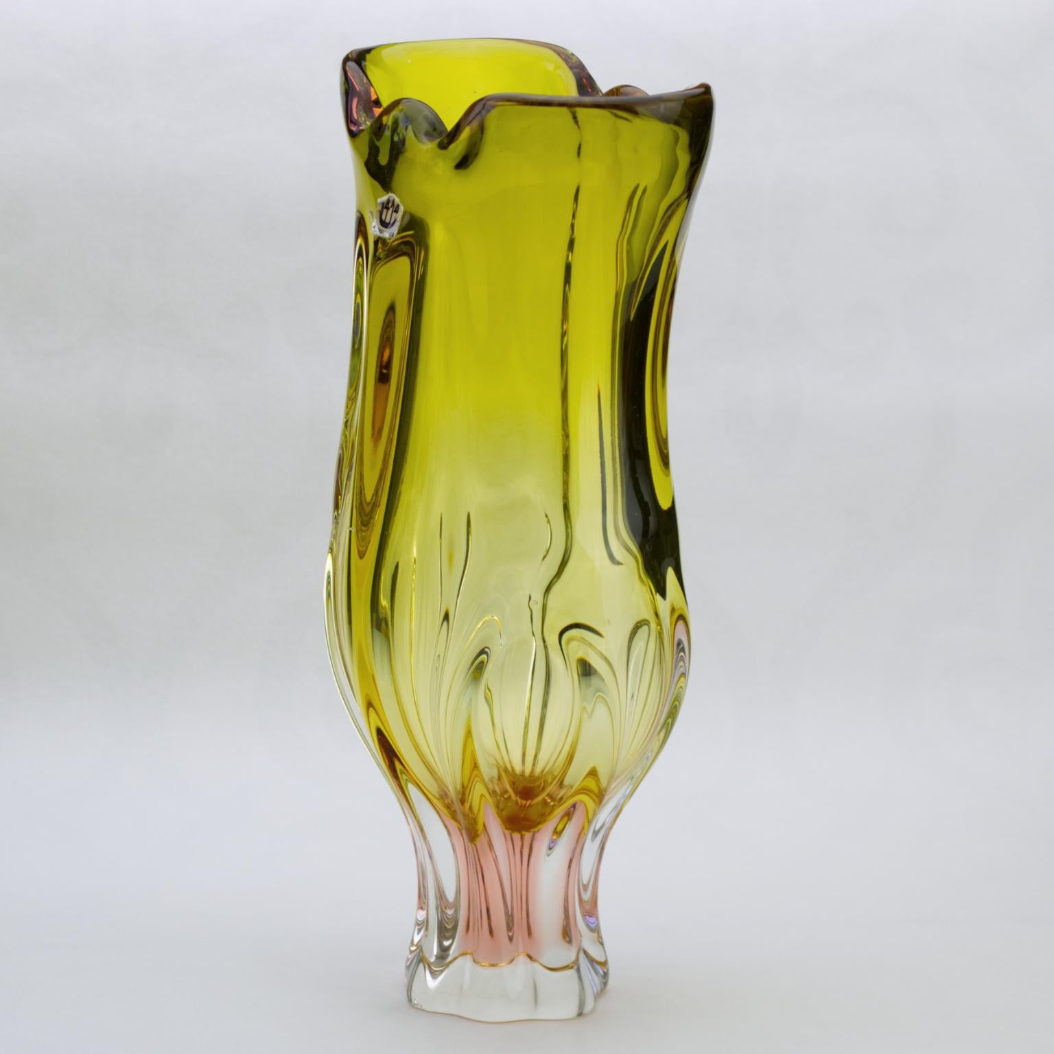 This wonderful high massive art glass vase made in yellow and pink color glass with clear massive base and lotus flower shaped top was designed by Josef Hospodka and made in the 1960s by Chribska glasswork.
The Chribska glassworks, full name