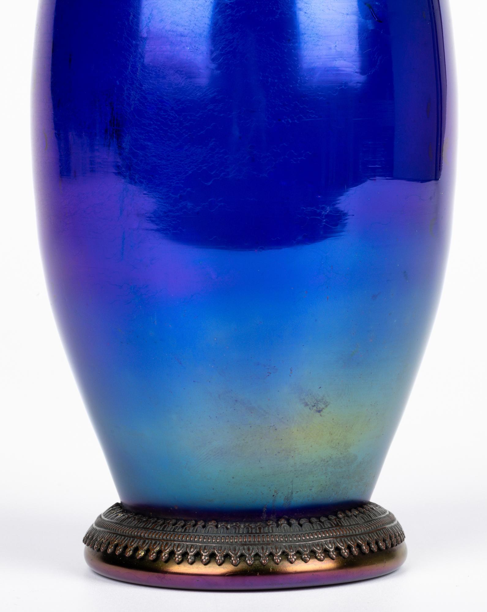Uno splendido vaso in vetro artistico cangiante blu Art Nouveau boemo con montature in metallo attribuito a Rindskopf, Kralik o Palme Konig e risalente al 1900 circa. Questo vaso soffiato a mano dalla forma elegante poggia su una base rotonda in