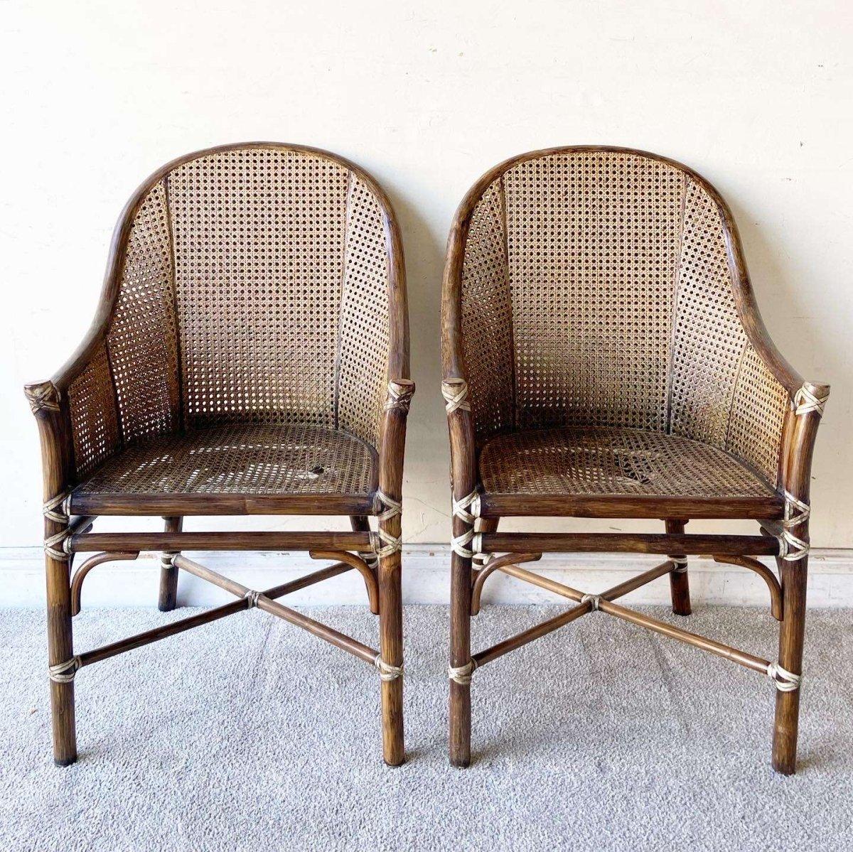 Excepcional juego de 4 sillones bohemios vintage de McGuire Furniture. Cada una presenta un acabado marrón en el bambú con juntas de ratán y caña en el respaldo, los laterales y el asiento. 