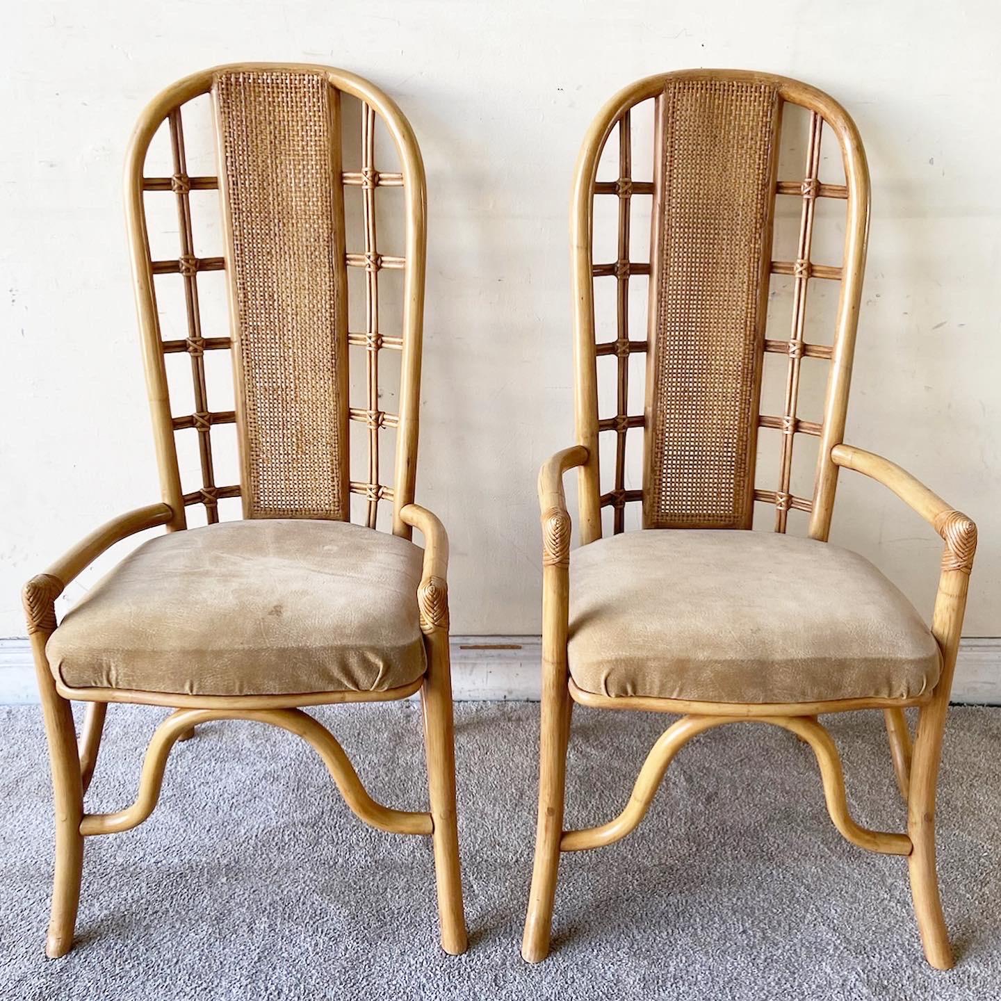 Exceptional set of 4 vintage boho chic dining chairs. Each feature a bamboo rattan frame with a cane back rest and brown leather seat.