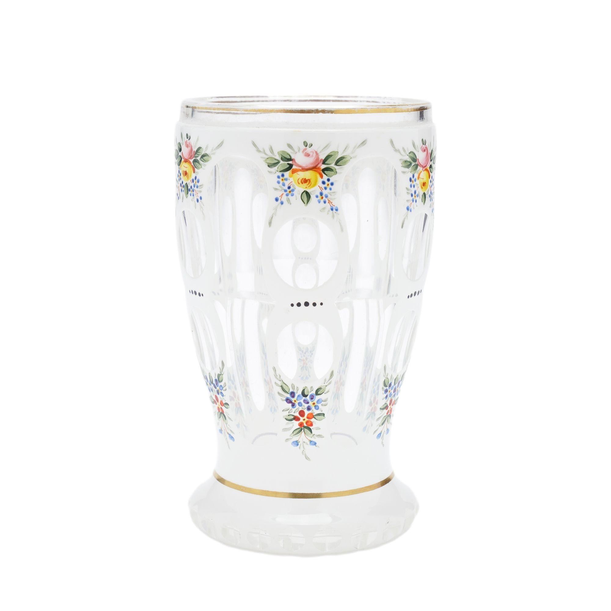 Vidrio spa soplado transparente y tallado, decorado en la capa blanca con ramos de hojas y flores esmaltadas policromadas.
Bohemia (actual República Checa), hacia 1825-45.

Dimensiones: 3-1/4