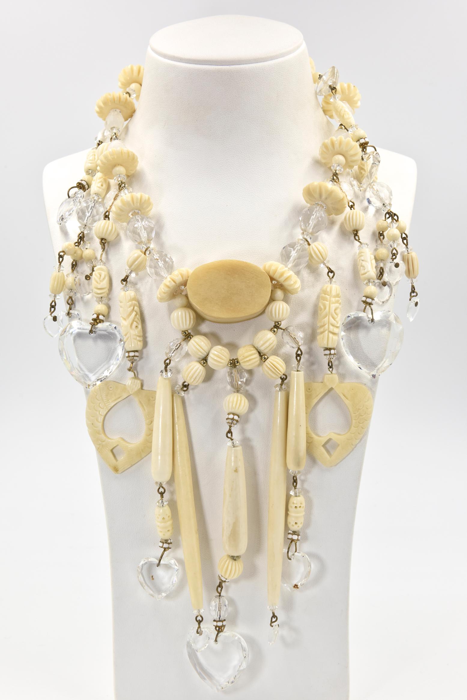 From a Miami socialite's estate, this necklace and matching earrings  are truly a statement piece.  Made in the 1980's, the necklace has carved and smooth bone pieces with gold tone bead accents as well as facetted crystal beads and hearts.    The