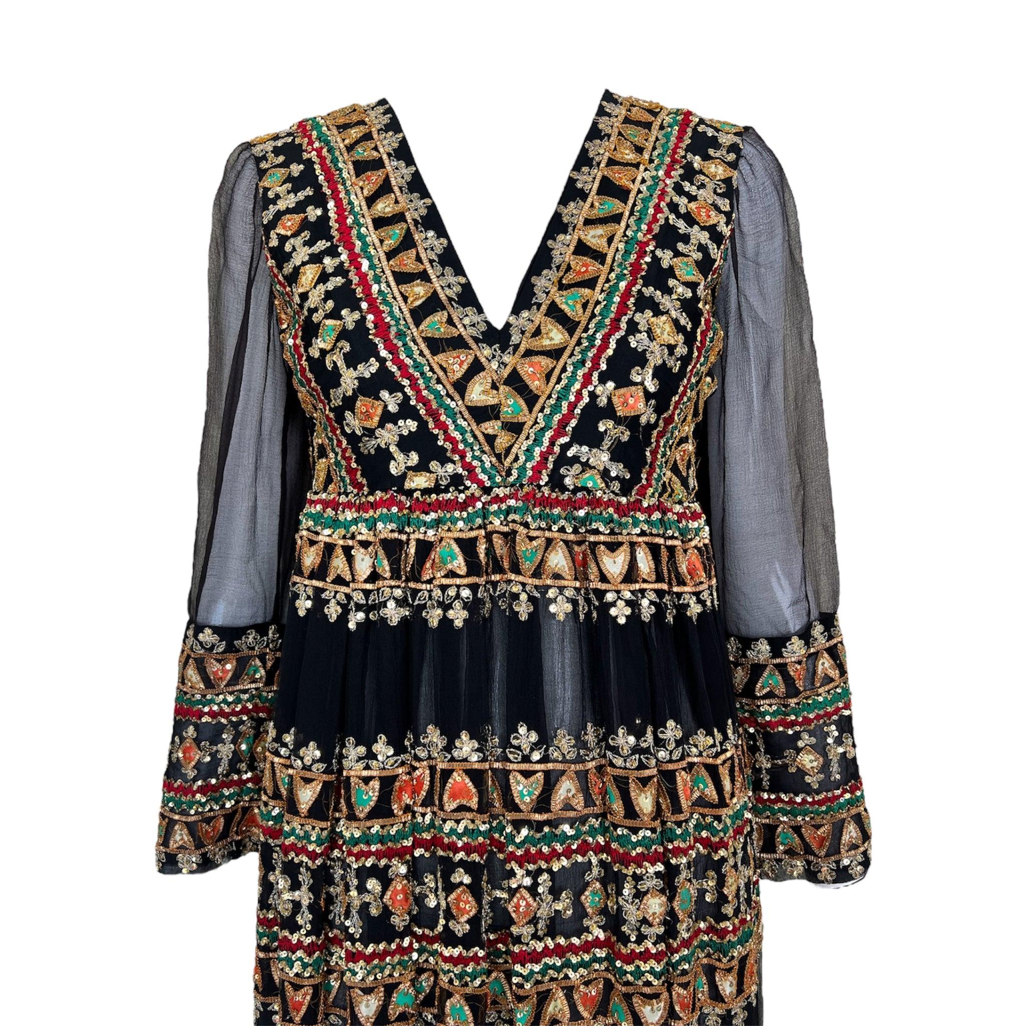 An incredible time capsule piece that beautifully captures the late 1960's and early 1970's fascination with Indian textiles. Delicate black silk chiffon with heavy embellishing of gold micro-sequins, red and green embroidery, and orange, green, and