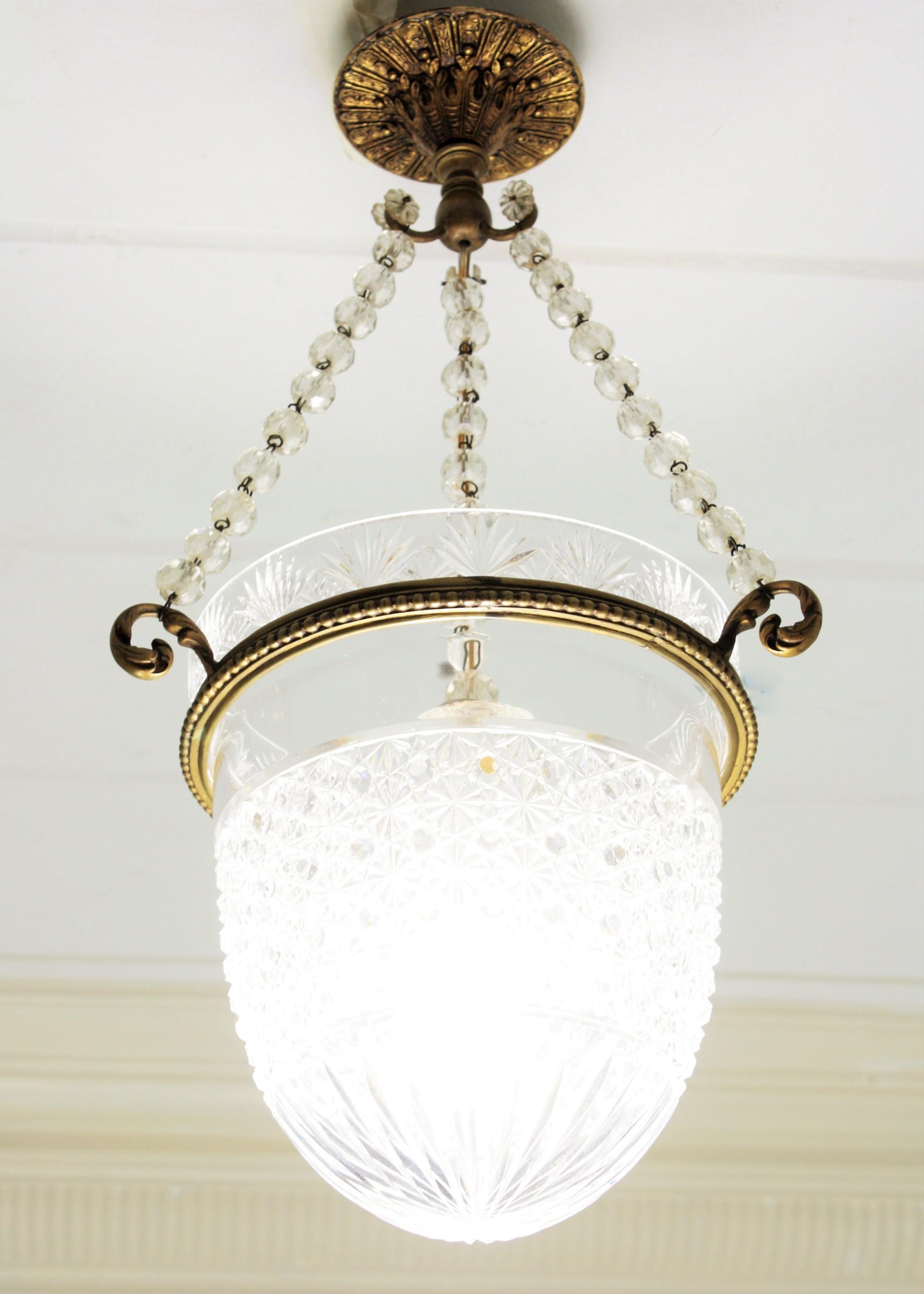 Empire Bohemian crystal and bronze bell jar pendant hanging light or chandelier. Czech Republic, 1920s-1930s
This elegant hanging light or pendant has a bell in Classic form and featuring bronze leafed scrolled ending hooks. The crystal bell shade