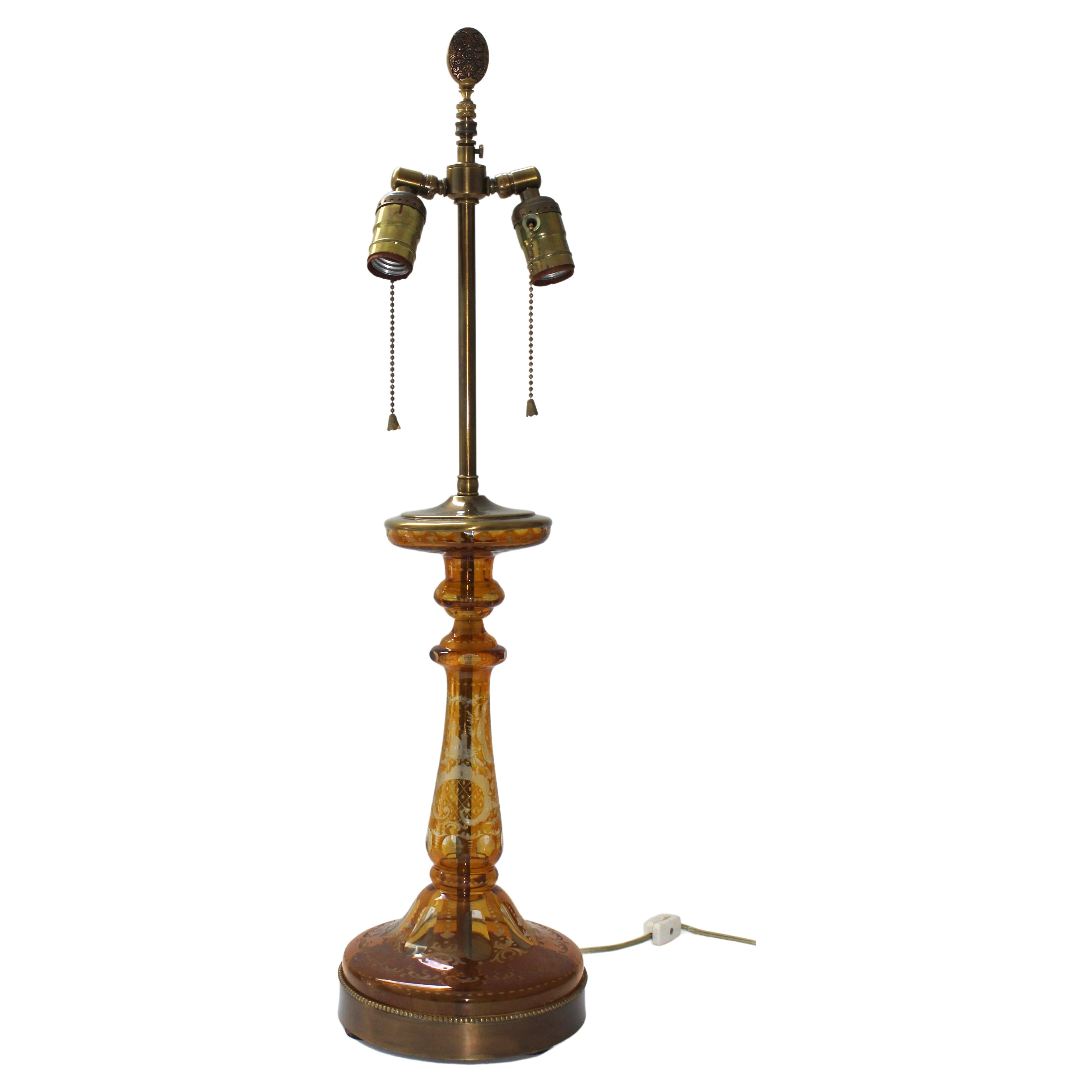 This stylsh Bohemian glass lamp started its life as a candlestick and at some point in time was converted to a table lamp. The piece is hand eteched with Baroque inspired cartouches, a castle and a leaping deer. And the antique brass hardware