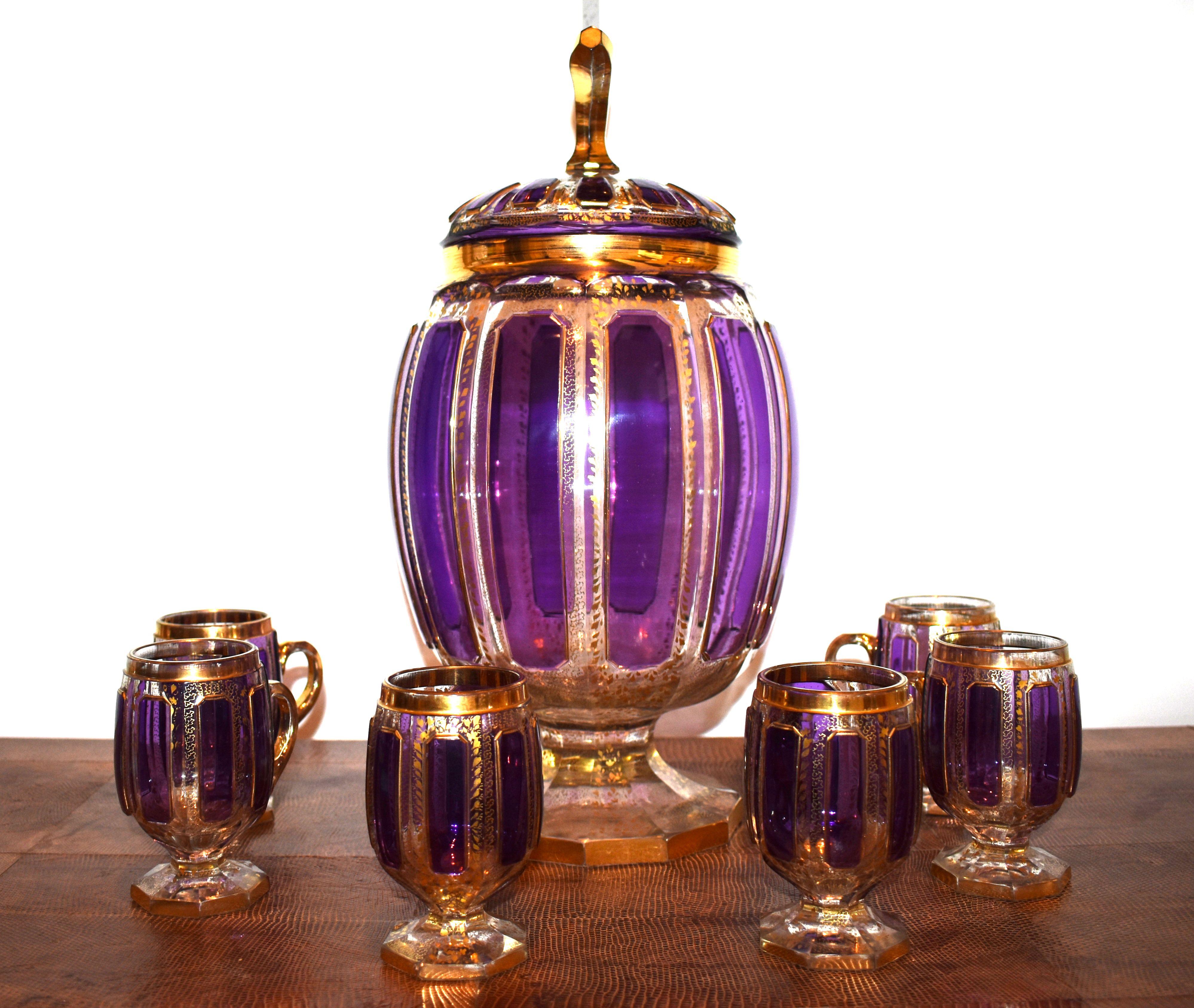 Set of Bohemian hand blown crystal glassware. Six cuts with a large pitcher gilded gold, purple and clear crystal.

Dimensions:
Pitcher 16 inches H by 8 Inches Dia.

Cup 4.25 inches H by 4 inches W including handle 2.25 inches D.