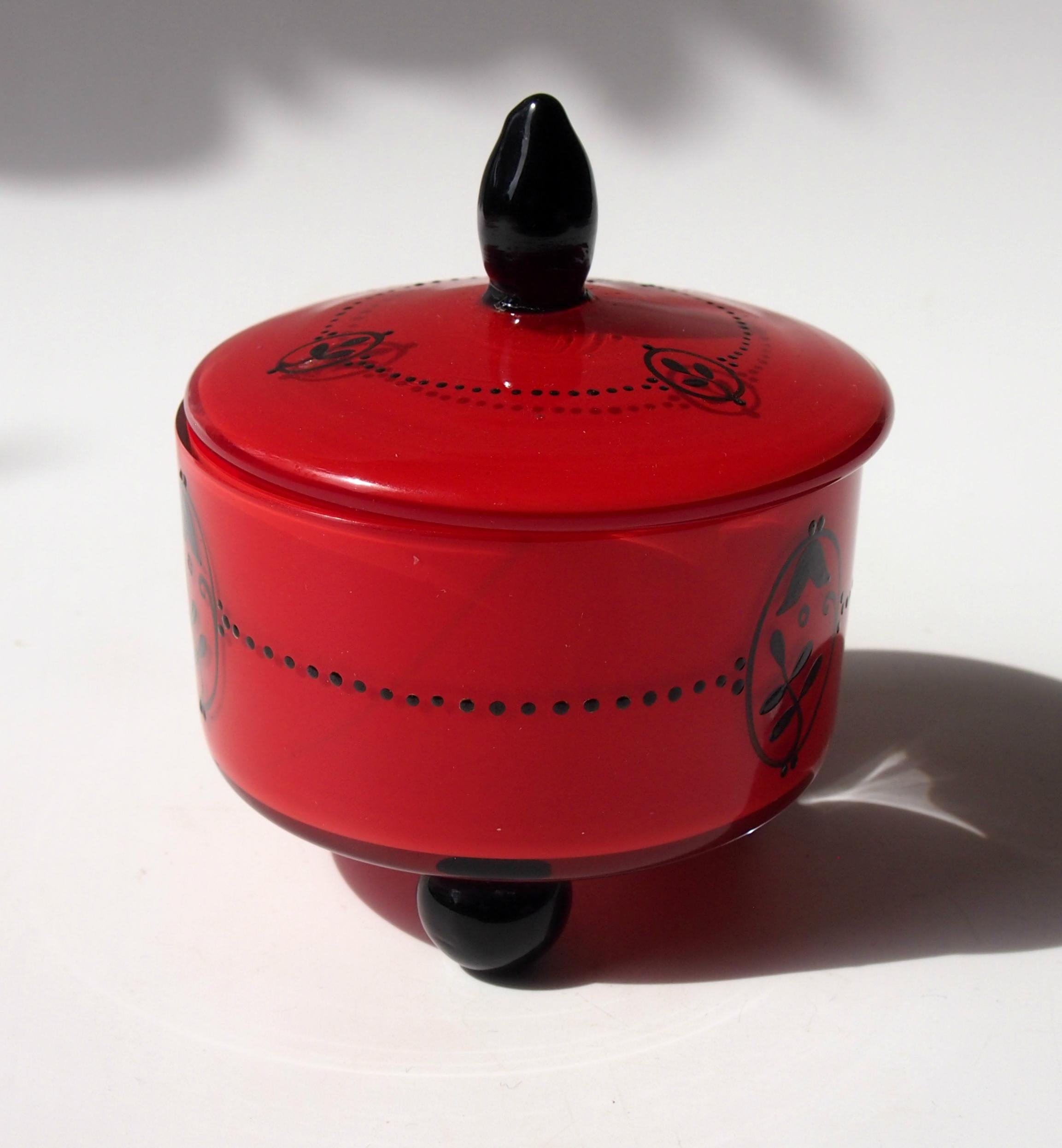 Rare red tango box and cover by Loetz enameled in black with black feet and lid finial. Designed by one of their greatest designers - Dagobert Peche. 

Loetz was by far the most important art glass house in the Bohemian region in the first quarter