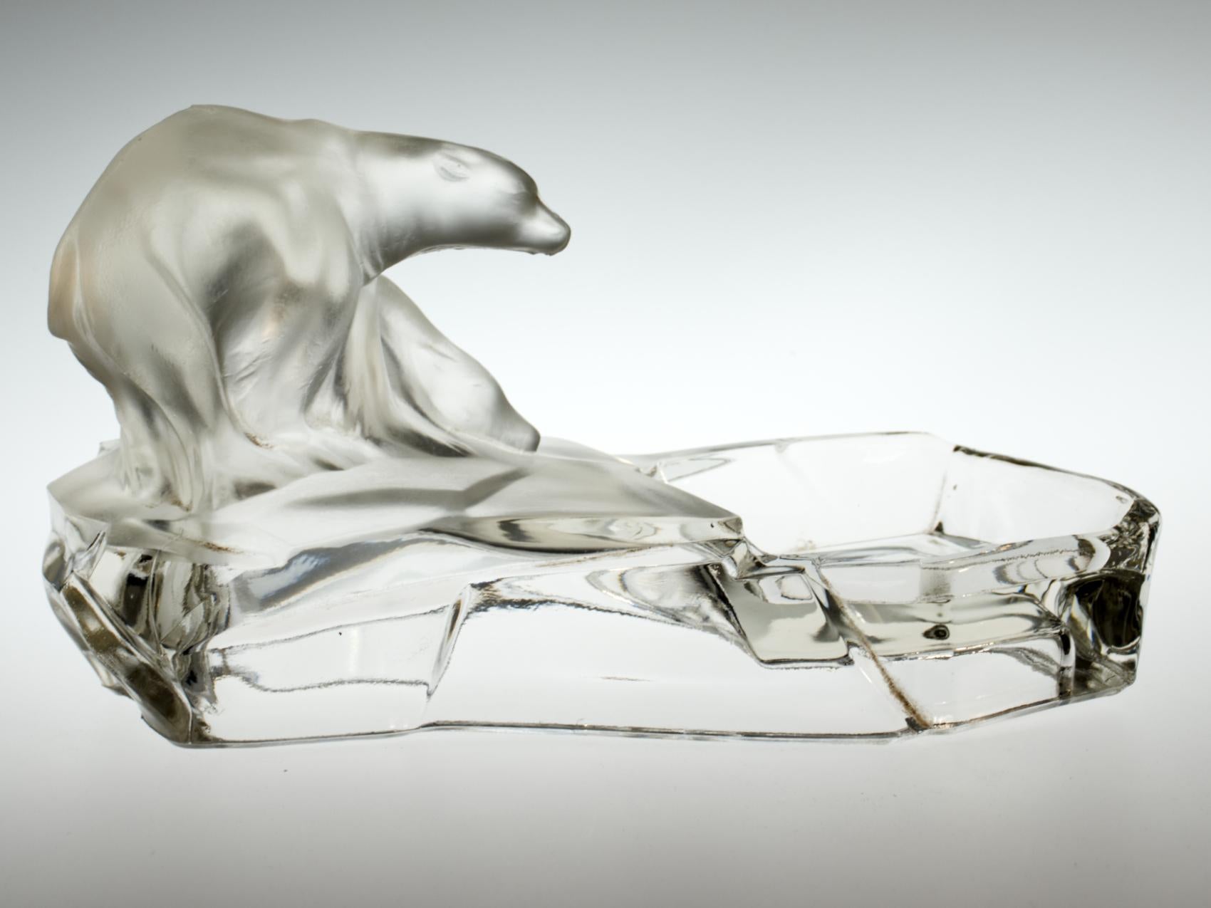Made by Feigl and Morawetz Libochovice and designed by the Czech sculptor Karel Zentner. An antique figurative ashtray made out of clear pressed glass, partially frosted. Figurative scheme showing two polar bears sitting on an iceberg.
Measures: 24