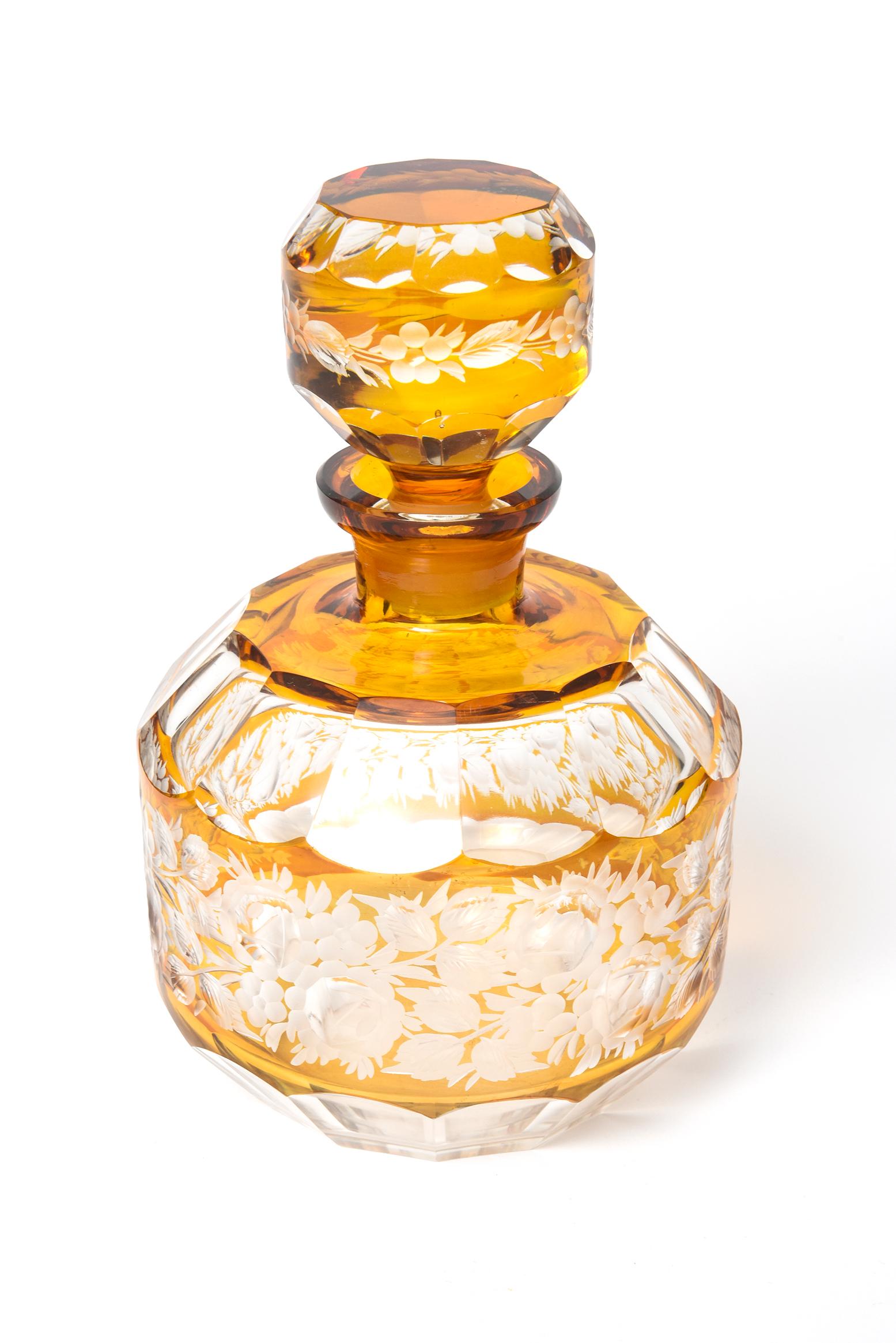 Early 20th Century amber cut to clear Bohemian crystal decanter engraved with a horizontal floral design. 
Beautiful optical white and amber glass decorated with cut-to-clear technique and etched floral cuts. There is floral engraving on the body