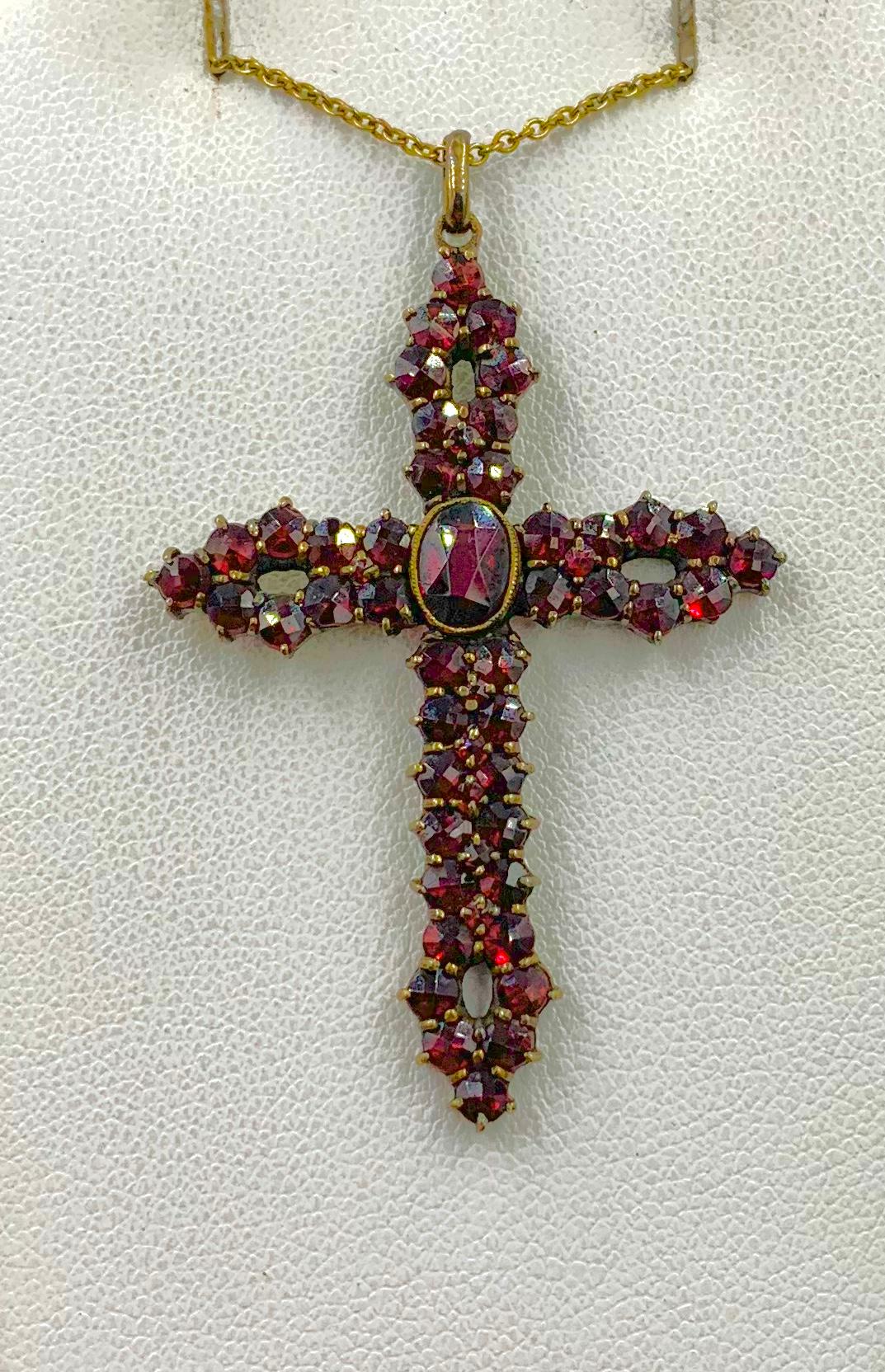 The Victorian Garnet Cross Pendant is a masterpiece of Victorian Garnet Jewelry.  It has a beautiful cross in an open work design set with stunning faceted natural mined Bohemian Garnets.  The beautiful garnets have the most fabulous blood red color