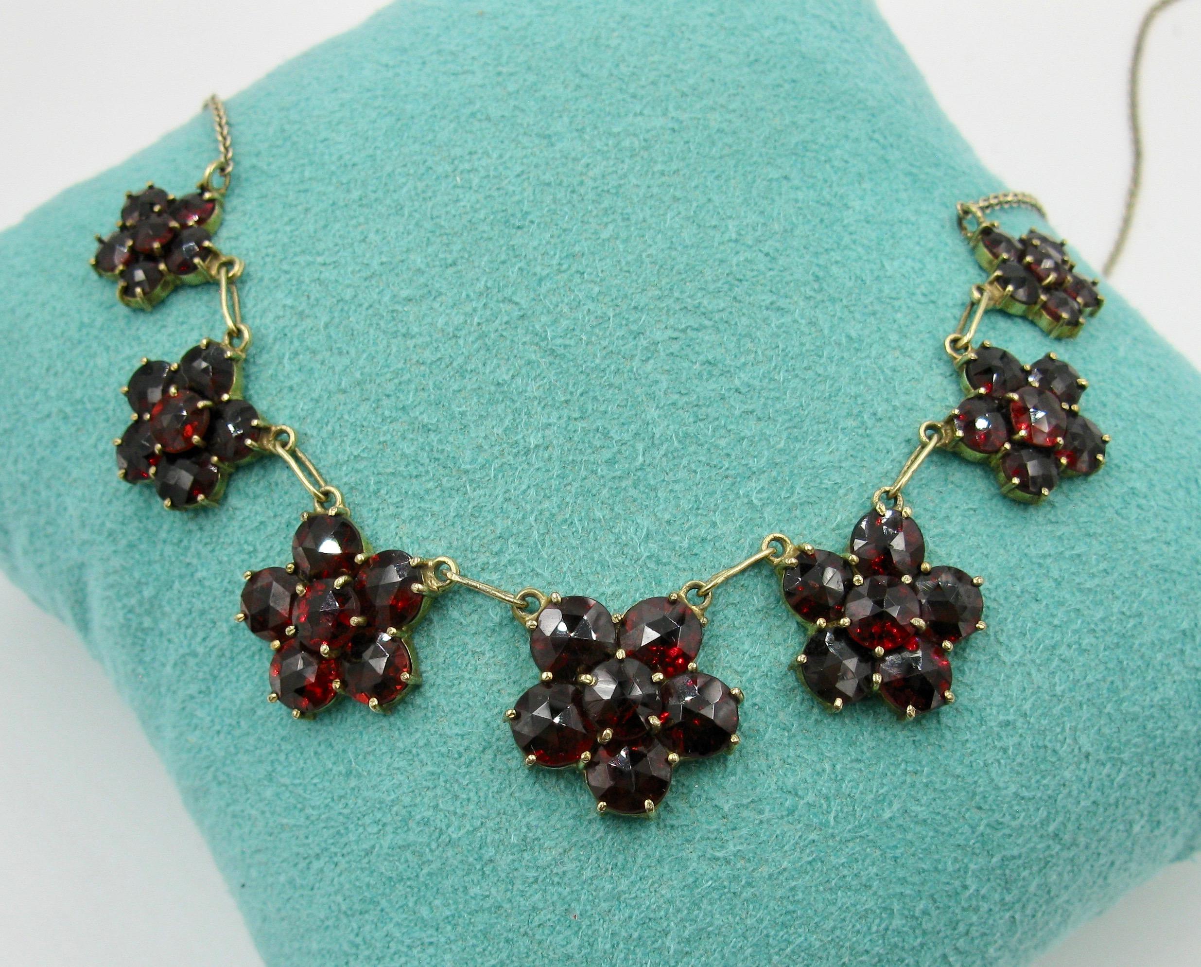 A GORGEOUS ANTIQUE VICTORIAN BELLE EPOQUE NATURAL BOHEMIAN GARNET NECKLACE WITH FLOWER FLORETS IN THE CHAIN OF SUPERB LARGE DEEP RED WINE GARNETS OF THE HIGHEST QUALITY SET IN SOLID 9 CARAT ROSE GOLD. DATING TO C1900.  MAGNIFICENT!
This is a