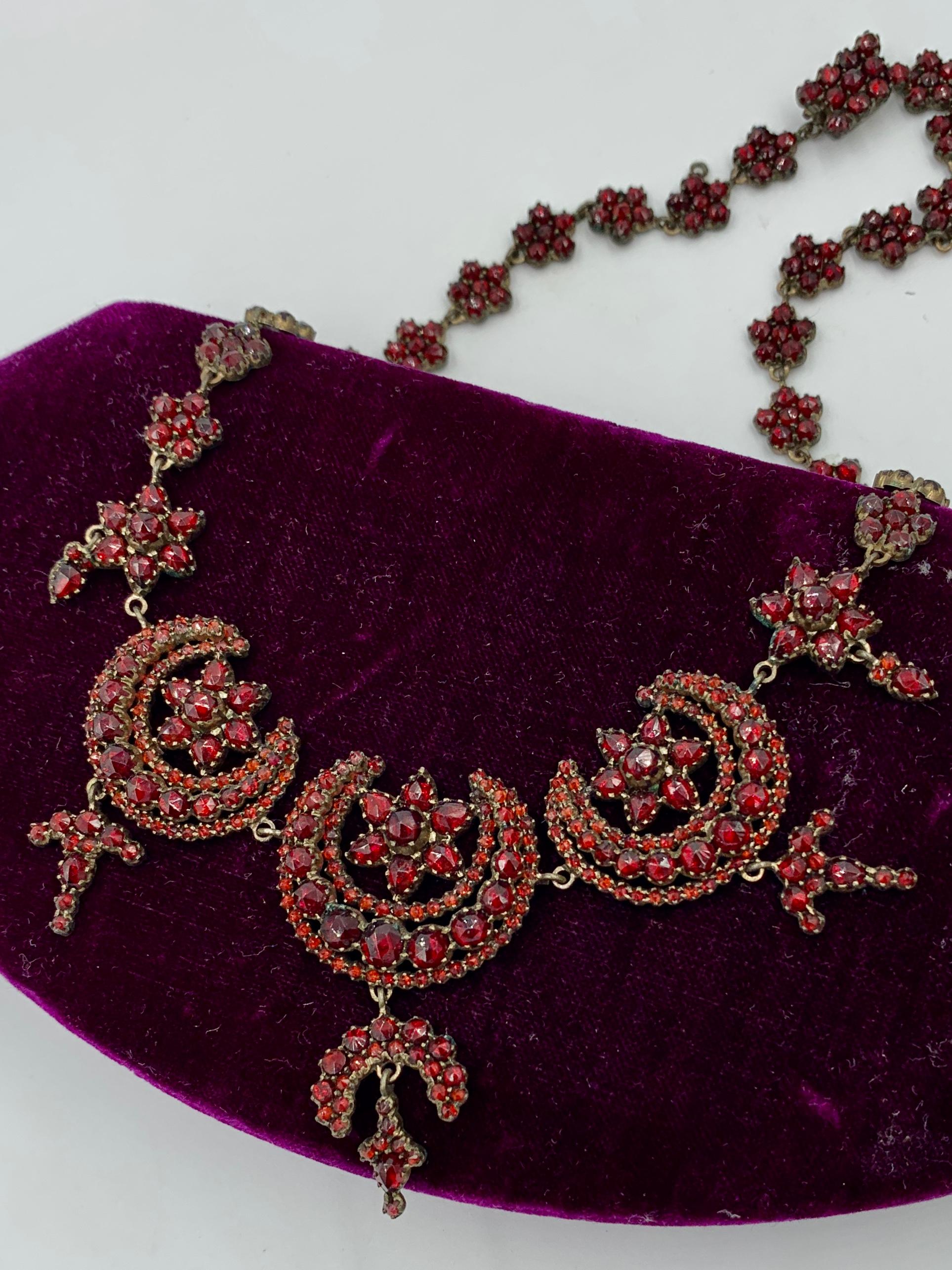 One of the finest Victorian Bohemian Garnet Parure with Necklace, Bracelet and Earrings that we have ever seen. The Garnet Necklace is a masterpiece of Victorian Garnet Jewelry.  It has Star and Moon center medallions with very deep garnets of the