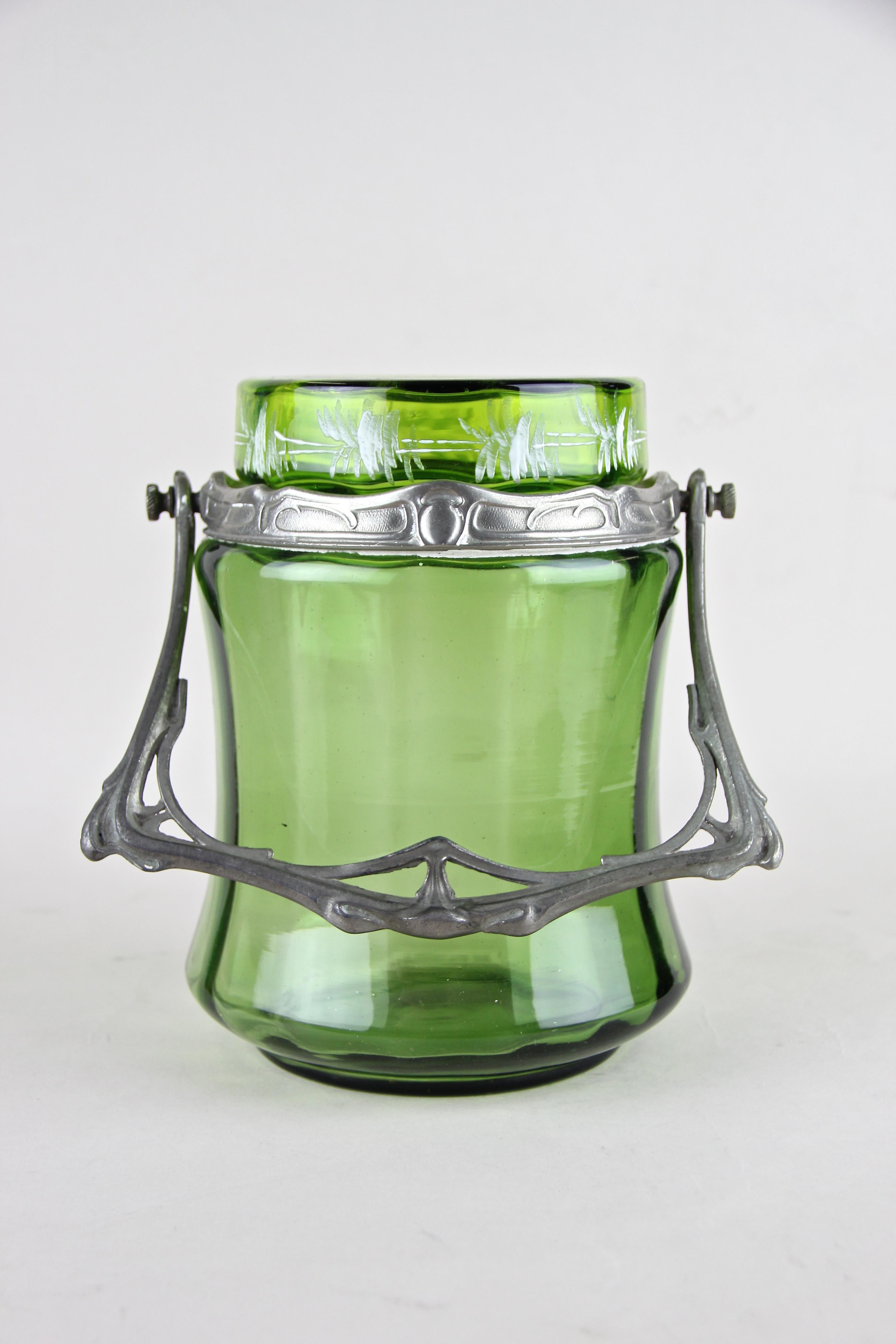 Lovely Bohemian glass jar with Lid from the beginning of the 20th century out of the Czech Republic. The beautiful shaped green glass jar comes with an artful, typically for the Art Nouveau era, designed tin mounting. A removable glass lid adorned
