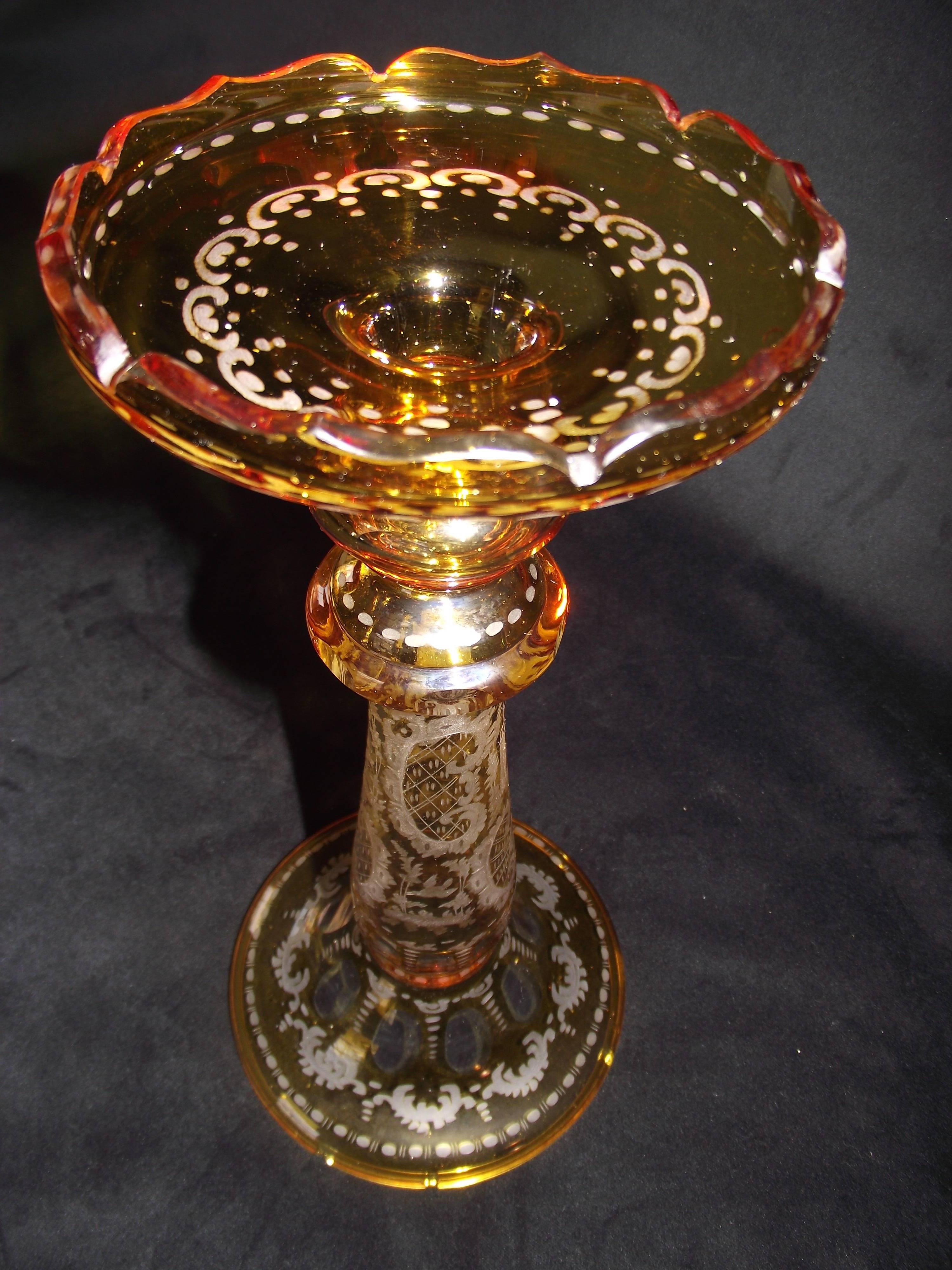 This beautiful Bohemian cut and etched glass piece serves dual duty. It can be a beautiful vase or if turned with the large end on the bottom it is a very impressive holder for a drum candle.

It has five small chips to the rim of the top if used