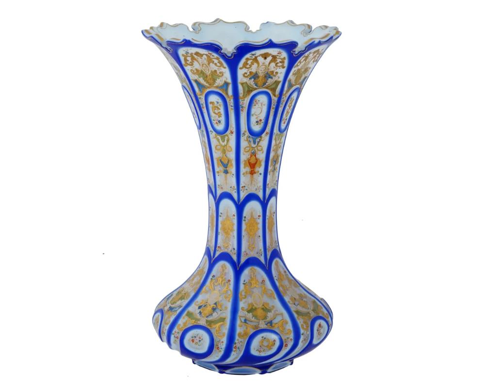 Antike böhmische Vase aus blauem, geschliffenem und klarem Opalglas mit geriffelter Mündung. Das Geschirr ist mit handemaillierten polychromen Paneelen verziert, auf denen Medaillons dargestellt sind, die von Blumen-, Laub- und Rankenmotiven umgeben