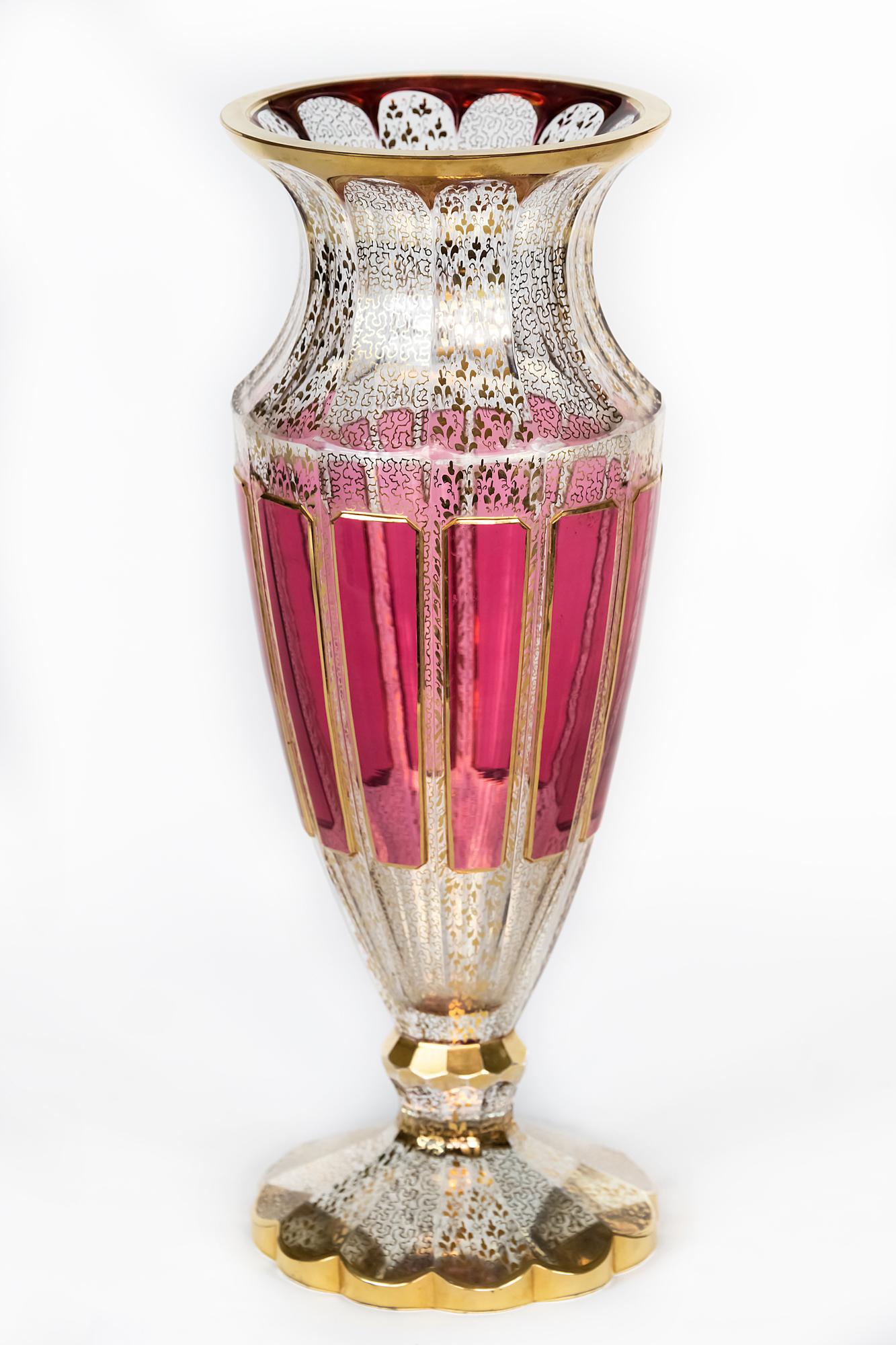Bohemian transparent glass vase decorated with raspberry colour glass, gilt trims and gold pattern through the glass.
The vase is heavy and in a very good antique condition.