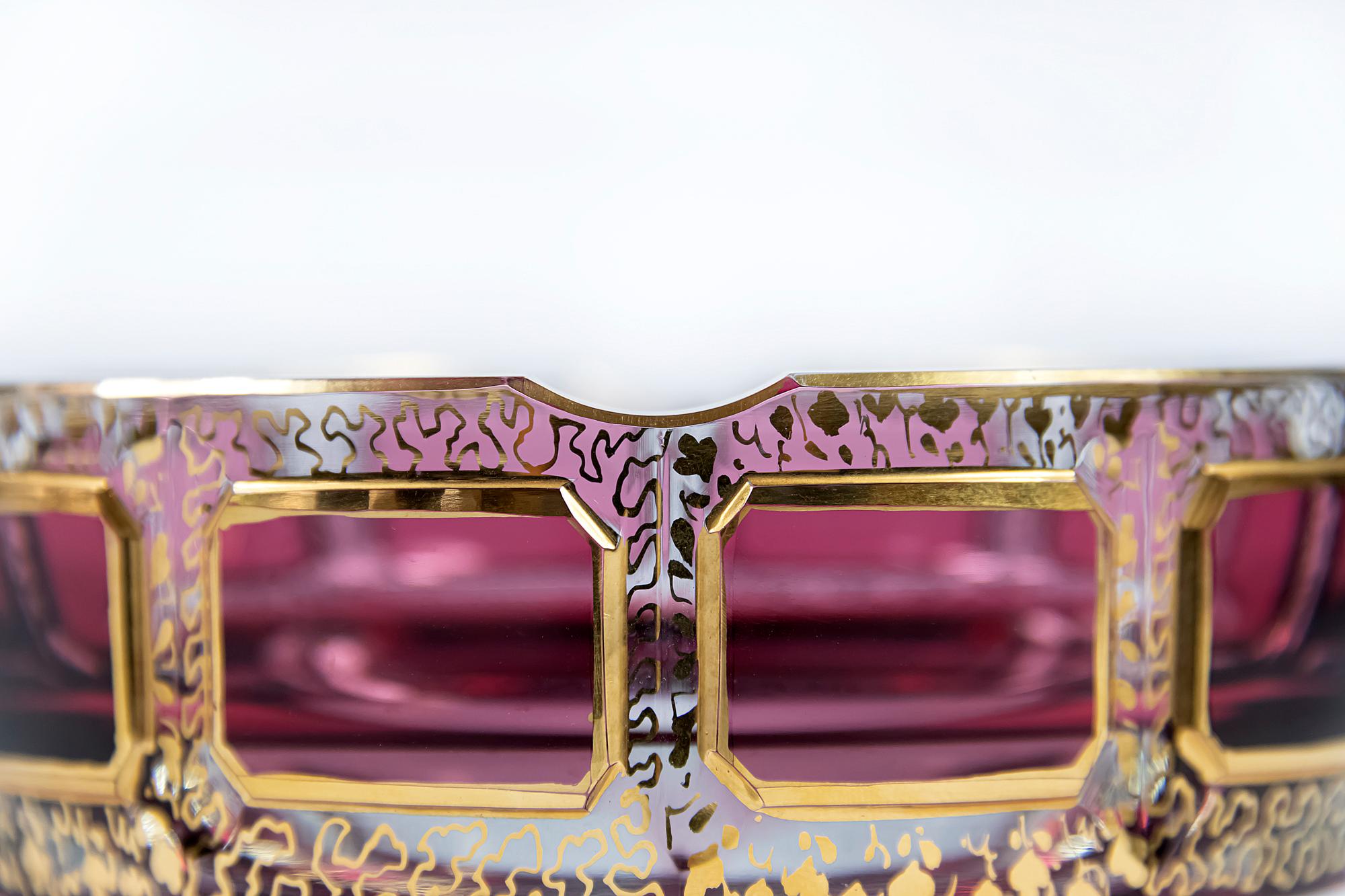 Bohemian glass ashtray.
Transparent glass decorated with raspberry color glass, gilt trims and gold pattern through the glass.