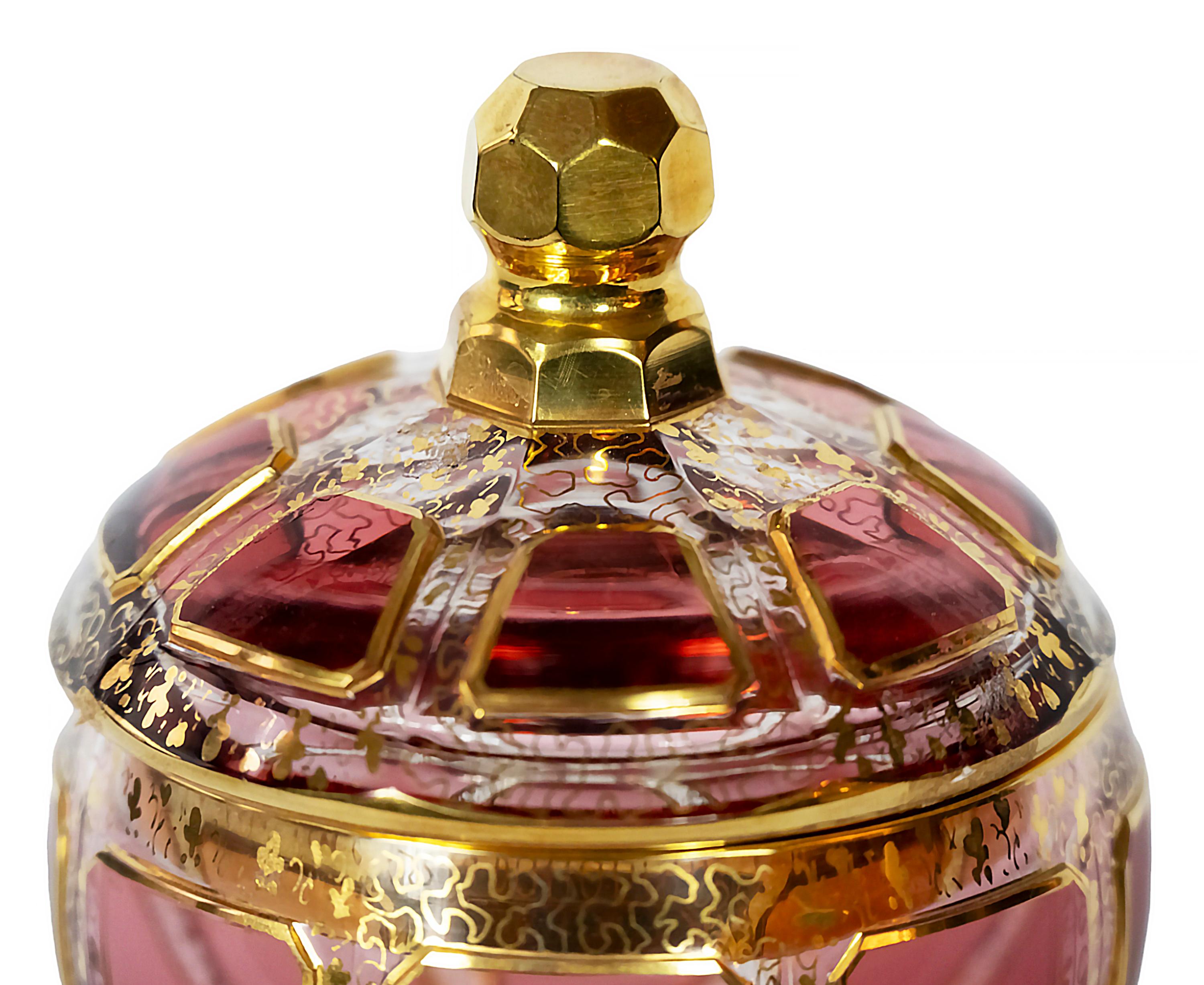 Bohemian glass lidded candy dish/box. 
Transparent glass decorated with raspberry colour glass, gilt trims and gold pattern through the glass.