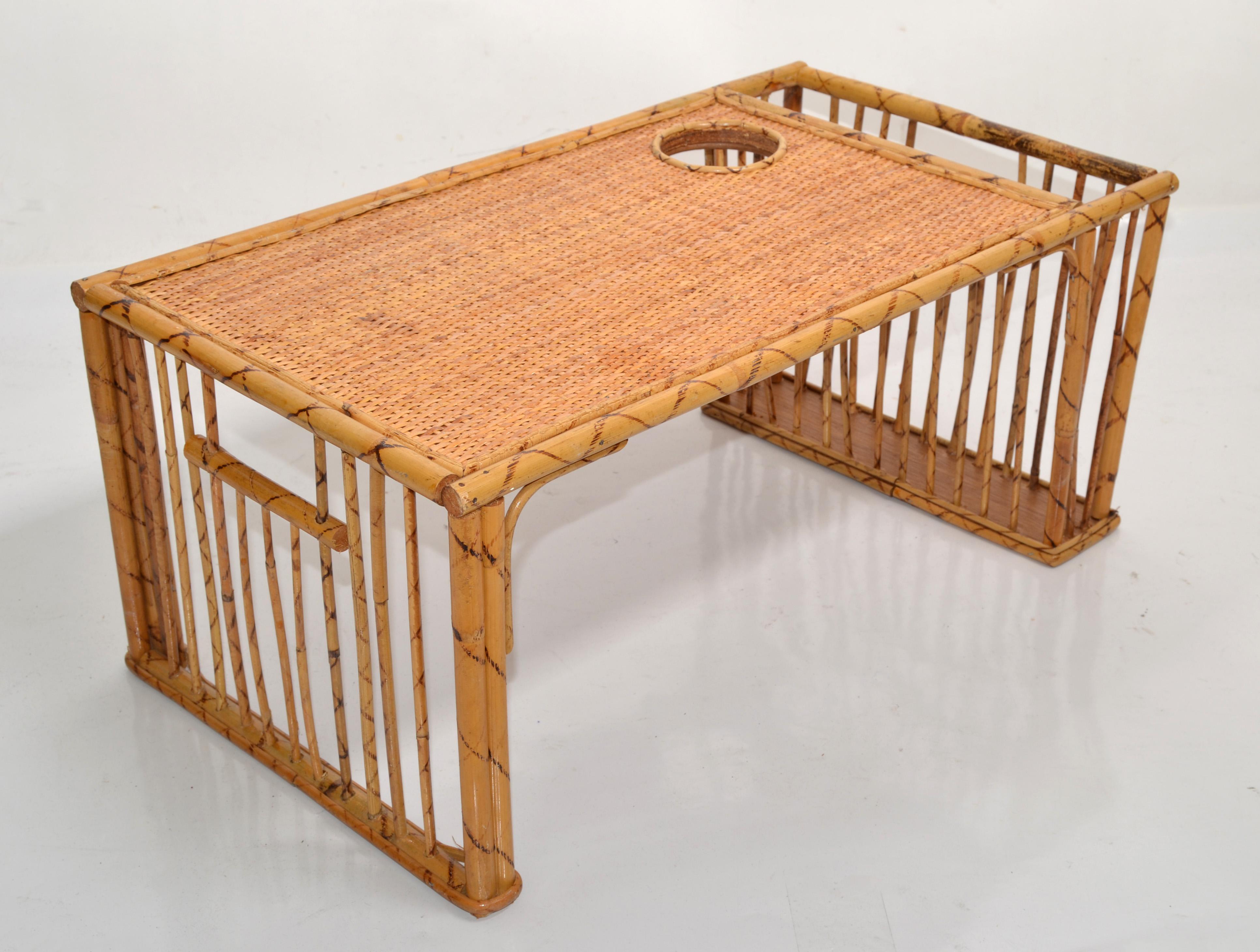 Add some Boho Chic vintage charm to your breakfast in bed with this amazing Tiger bamboo, caning and rattan bed tray table. 
Handwoven and hand-crafted in a medium yellow wood tone finish, this rectangular tray comes with a cup holder and magazine