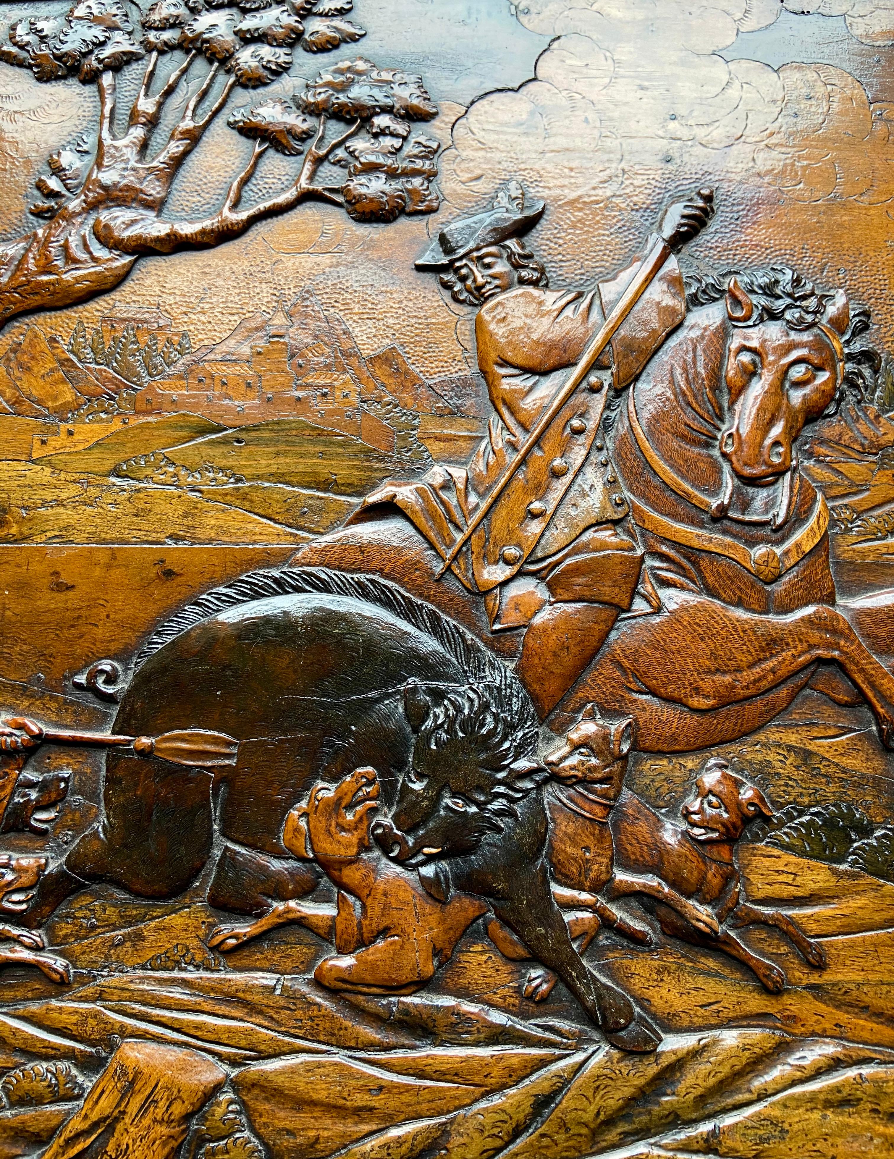 Attributed to Johann Karl Haberstumpf (active 1691-1724). An important relief carved walnut and fruitwood inlaid and partially stained folding games board, the front finely carved with a boar hunting scene with village beyond. The interior with