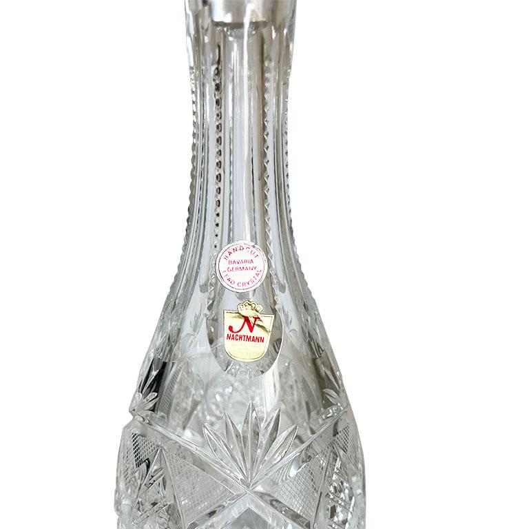An exquisite hand-cut crystal liquor decanter with the original glass stopper. This piece will be a great addition to any bar. It is tall and very heavy. Around its body are cut to clear geometric diamond patterns cut by hand. The neck of the bottle