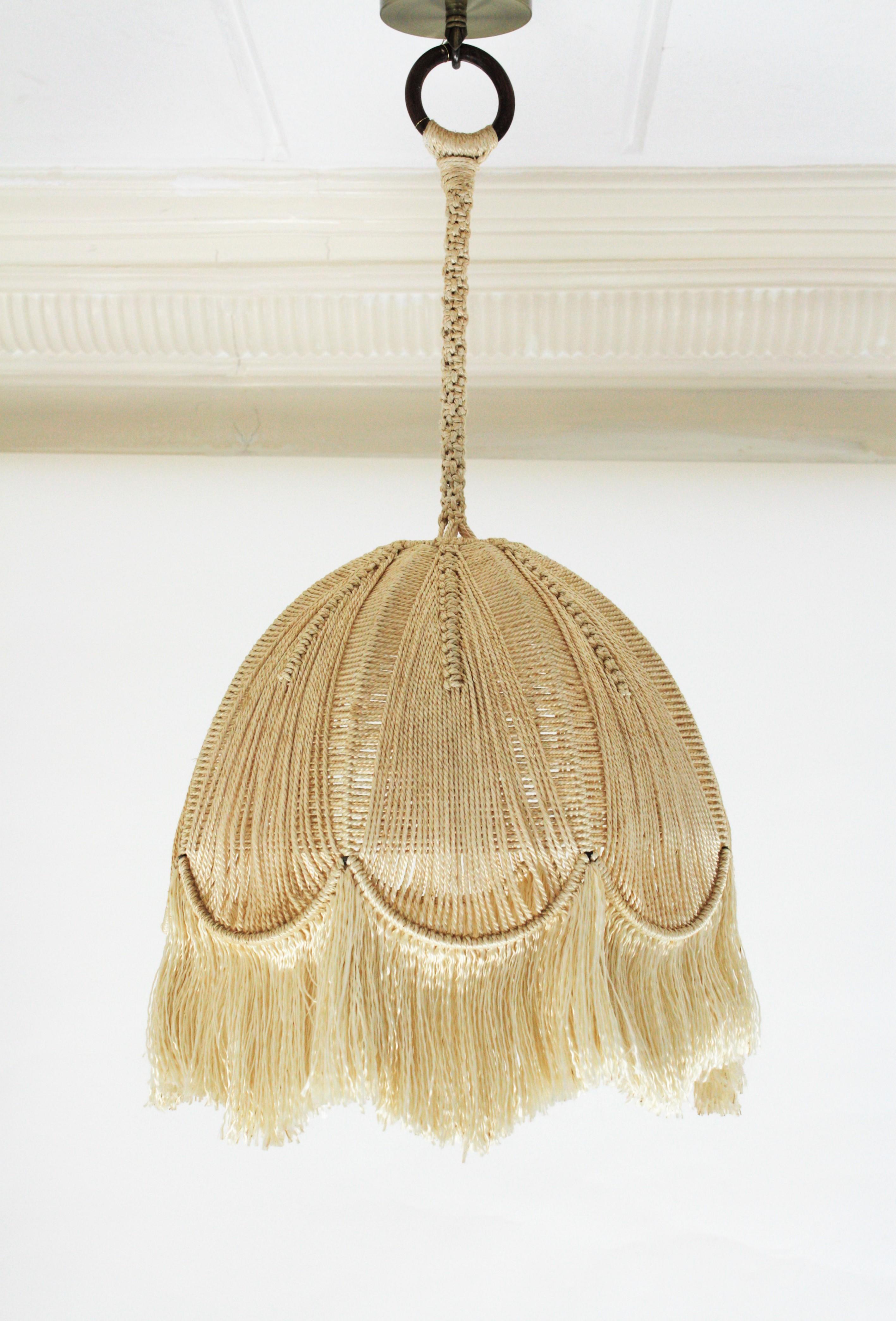 Lovely vintage original fiber macramé handcrafted bell shaped lantern / pendant, Spain, 1970s.
This eye-catching lamp features a bell shaped shade with hand braided and hand knotted macramé cord finished with a fringe at the bottom. It hangs from a