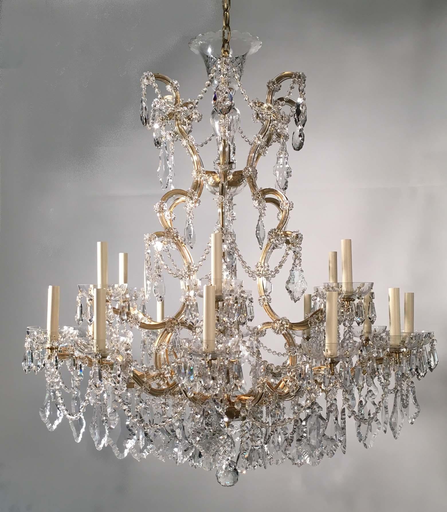 We call this type of high-quality chandelier a Maria Therese. It is chiefly distinguished from others by the fact that the arms are of flat metal but clad with crystal and applied with rosettes. They come in numerous sizes. They are a specialty of