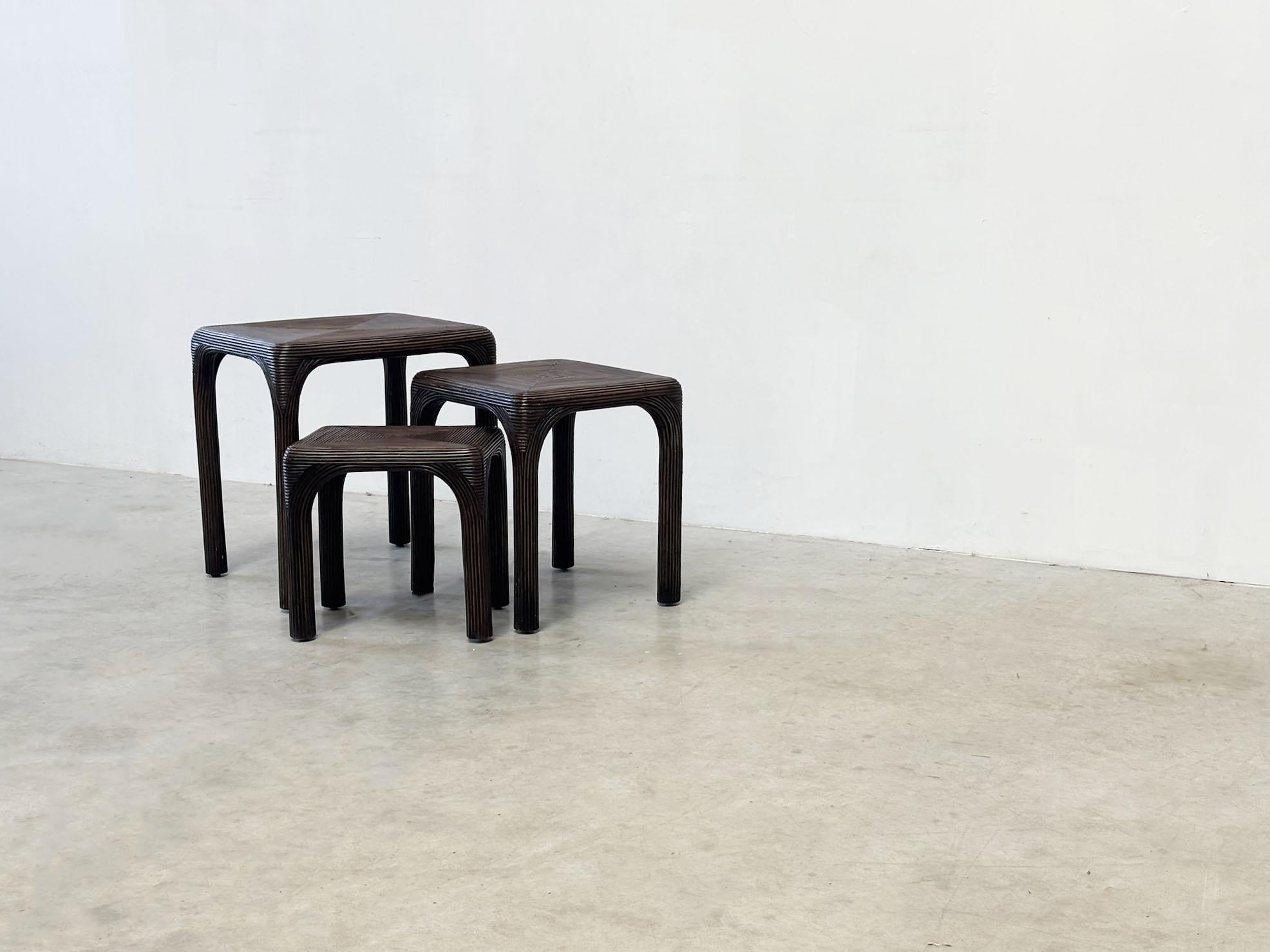 Cet ensemble de trois tables gigognes des années 1970, probablement de Vivai Del Sud, présente un cadre en bambou teinté foncé avec des motifs géométriques distinctifs. Leur texture riche et leur design unique en font un accent élégant et