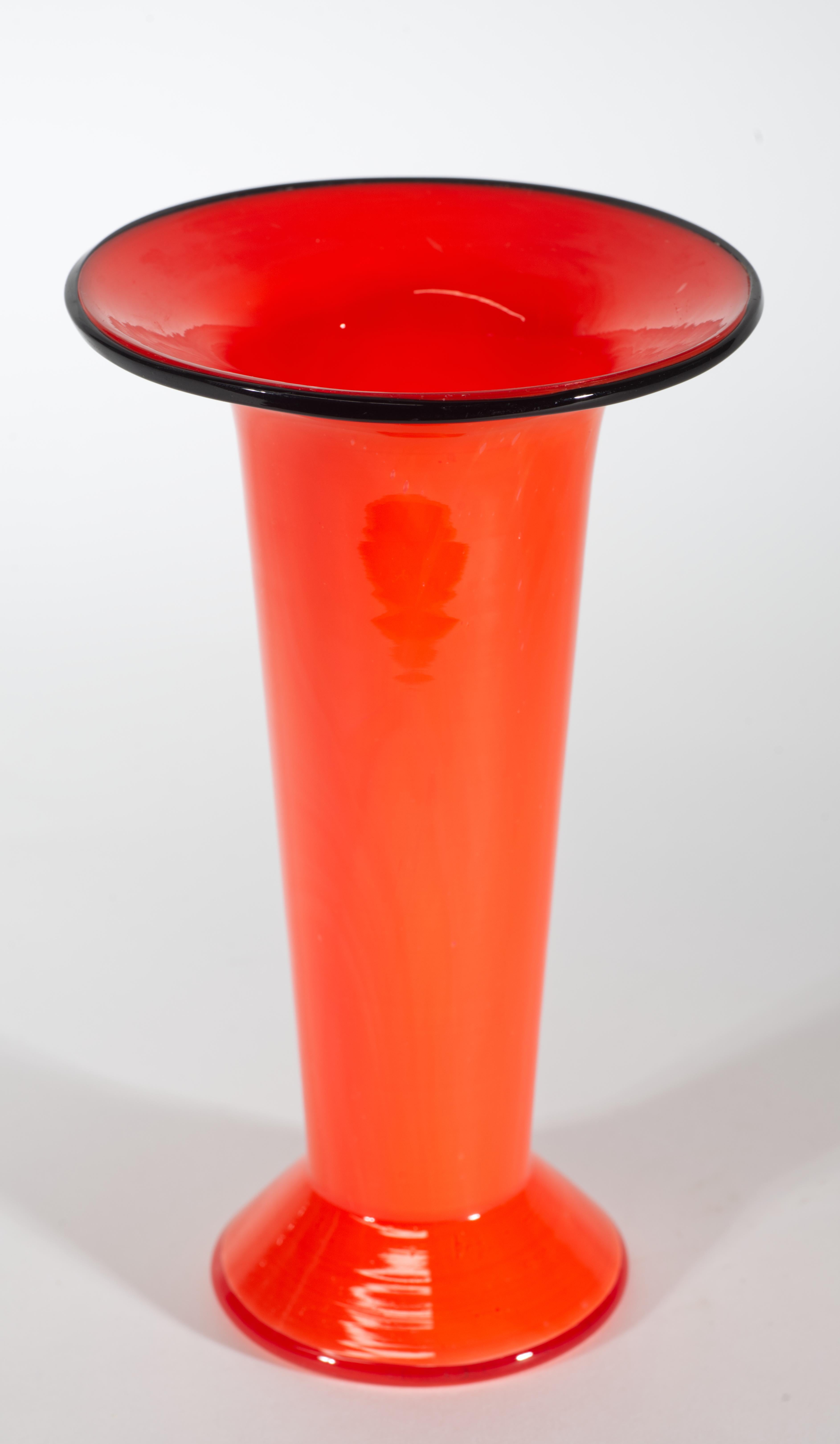  Il vaso vintage in vetro arancione tango con accenti neri è caratterizzato da una forma elegante e minimale e da una tavolozza di colori accattivanti. Il colore arancione corallo domina il design; il vetro colorato è racchiuso in un sottile strato