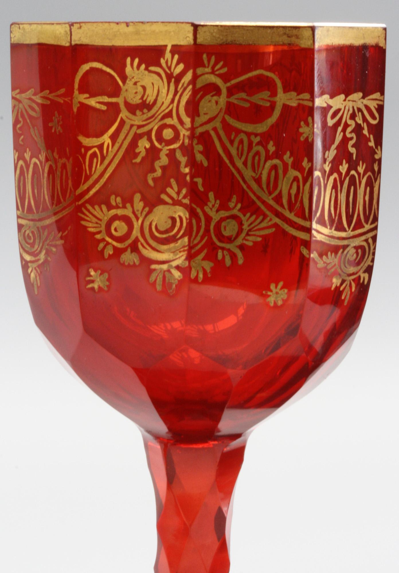 A very rare set Bohemian ruby red colored wine glasses with gilded patterning to the body and foot and dating from the early 19th century around 1810/20. These stylish glasses have wide rounded slightly domed feet decorated with small gilded star