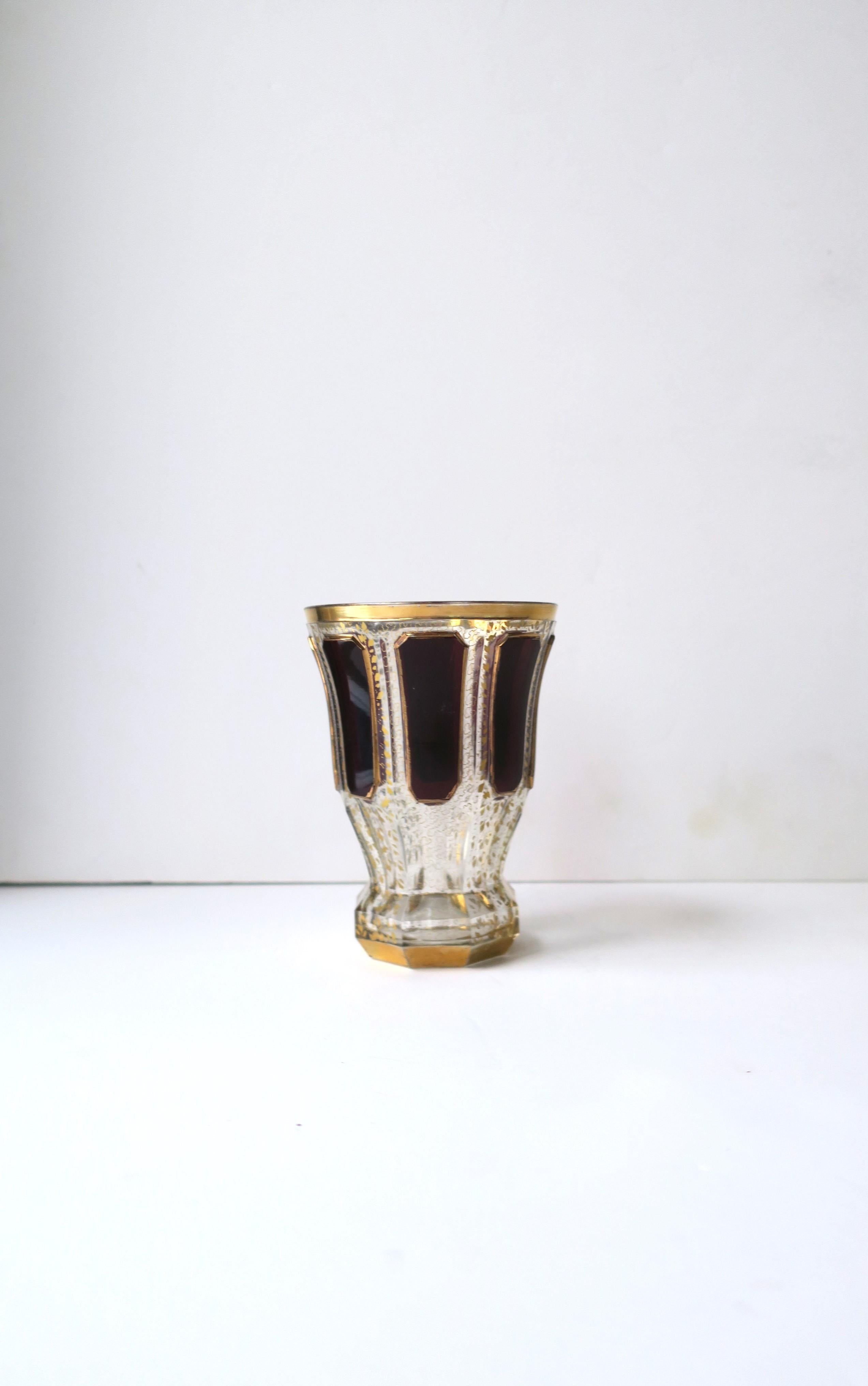 A beautiful Bohemian transparent/clear, red burgundy and gold gilt glass vase or beaker vessel, circa late-19th century, Czechoslovakia. Vessel is attributed to luxury crystal glass maker, Moser. Piece has beautiful details from top to bottom, in