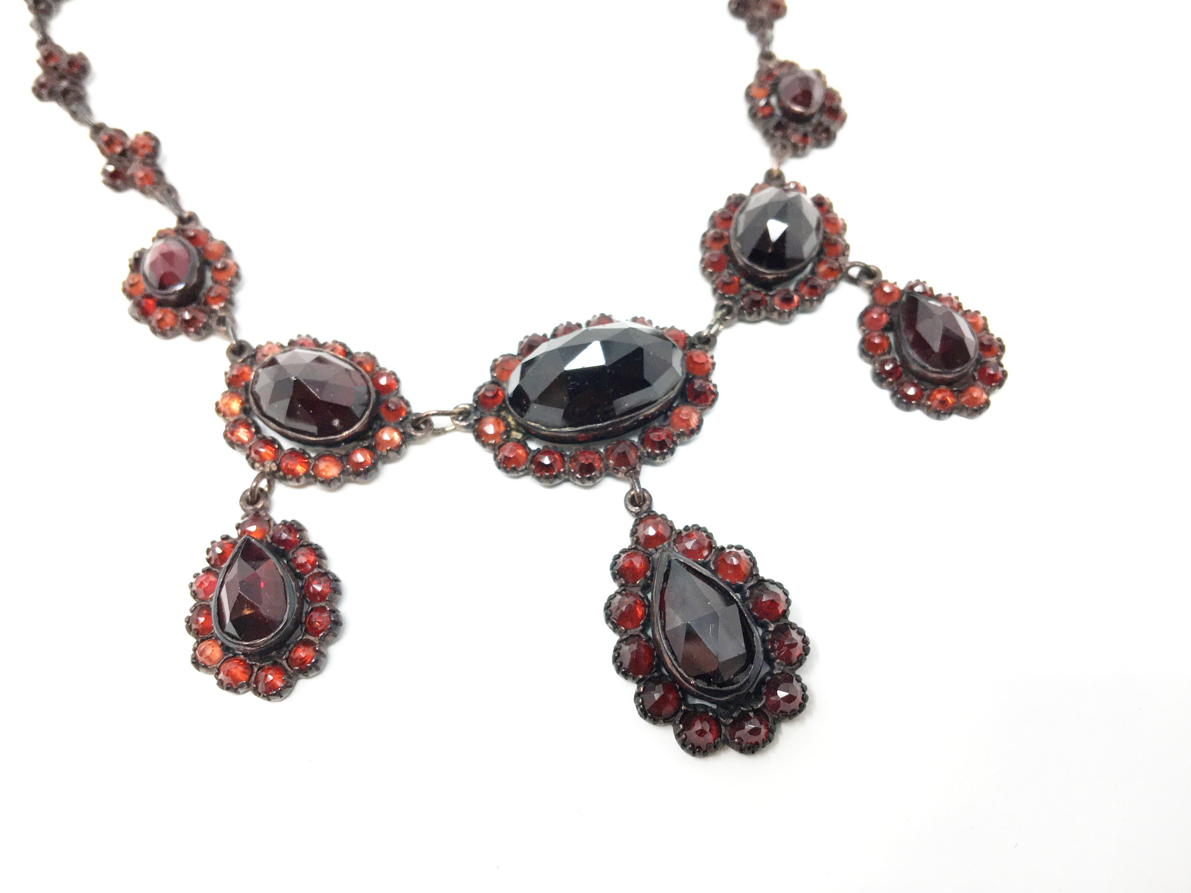 Beautiful Bohemian drop Garnet necklace. “pigeon blood” garnets set in an aged patina, Gilt silver (Gilded Rose tone metal over 625). Wear consistent with use and age, a few chips on the larger garnets. Length Necklace is 16.5