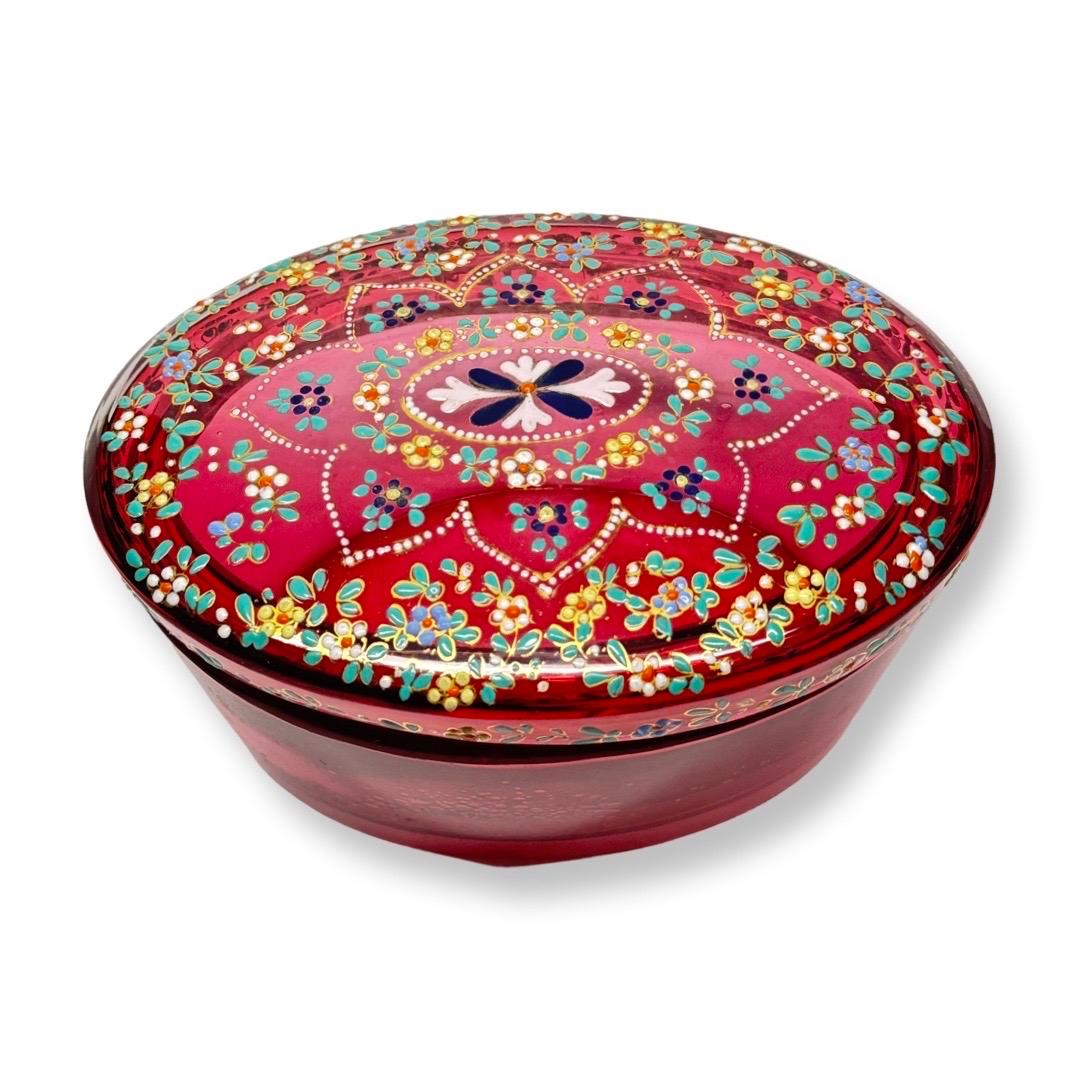 Una caja única de cristal rojo con esmalte pintado a mano, creada a finales del siglo XIX o principios del XX en Bohemia (Checoslovaquia), representa un raro ejemplo de artesanía vidriera excepcional. El rico color rojo del vidrio, conseguido