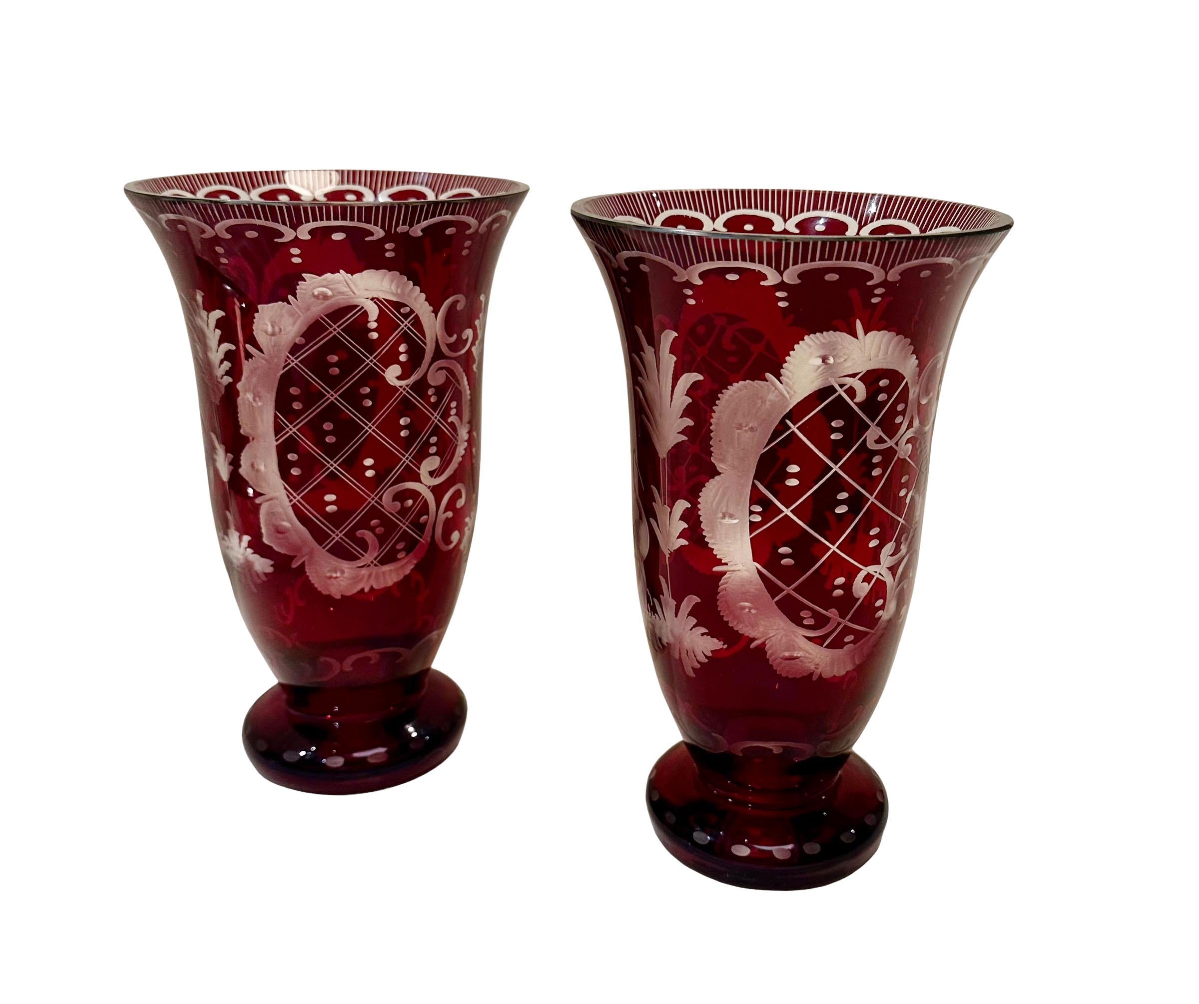 A pair of antique bohemian ruby red etched glass vases. Beautifully etched with birds, a castle in a rococo style they are in beautiful condition. Looks like they’ve never been used. Circa 1860s.