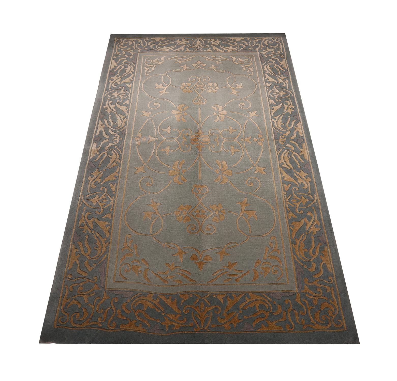 This fine silk rug was woven by hand in India in the early 21st century. The design has been woven on a subtle grey background with gold accents, making up a symmetrical elegant design. This vintage carpet has been woven to perfection and is sure to